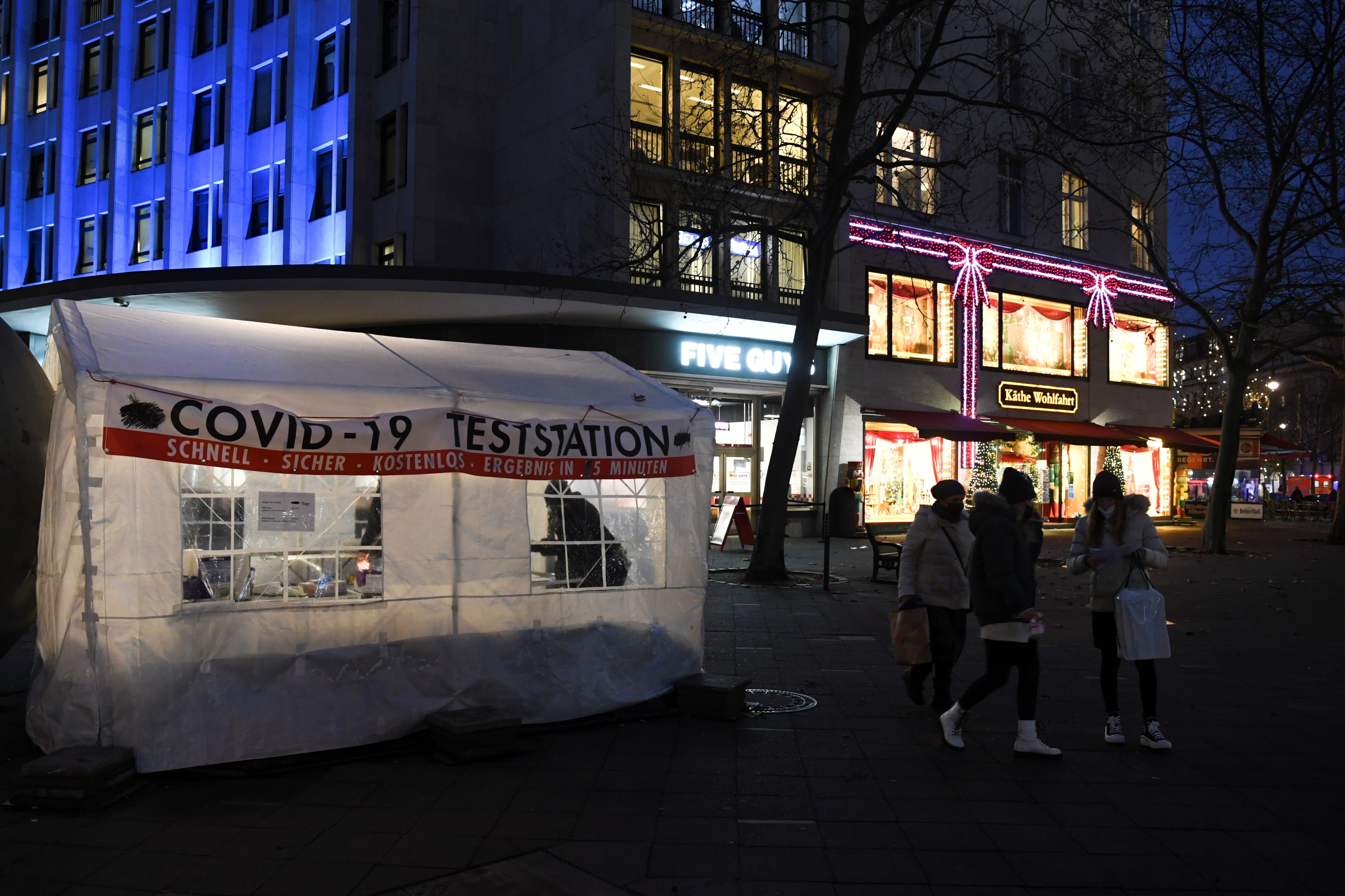 People walk by a COVID-19 testing station on the shopping street Kurfuerstendamm, amid the coronavirus disease (COVID-19) pandemic, in Berlin, Germany, December 1, 2021. REUTERS/Annegret Hilse