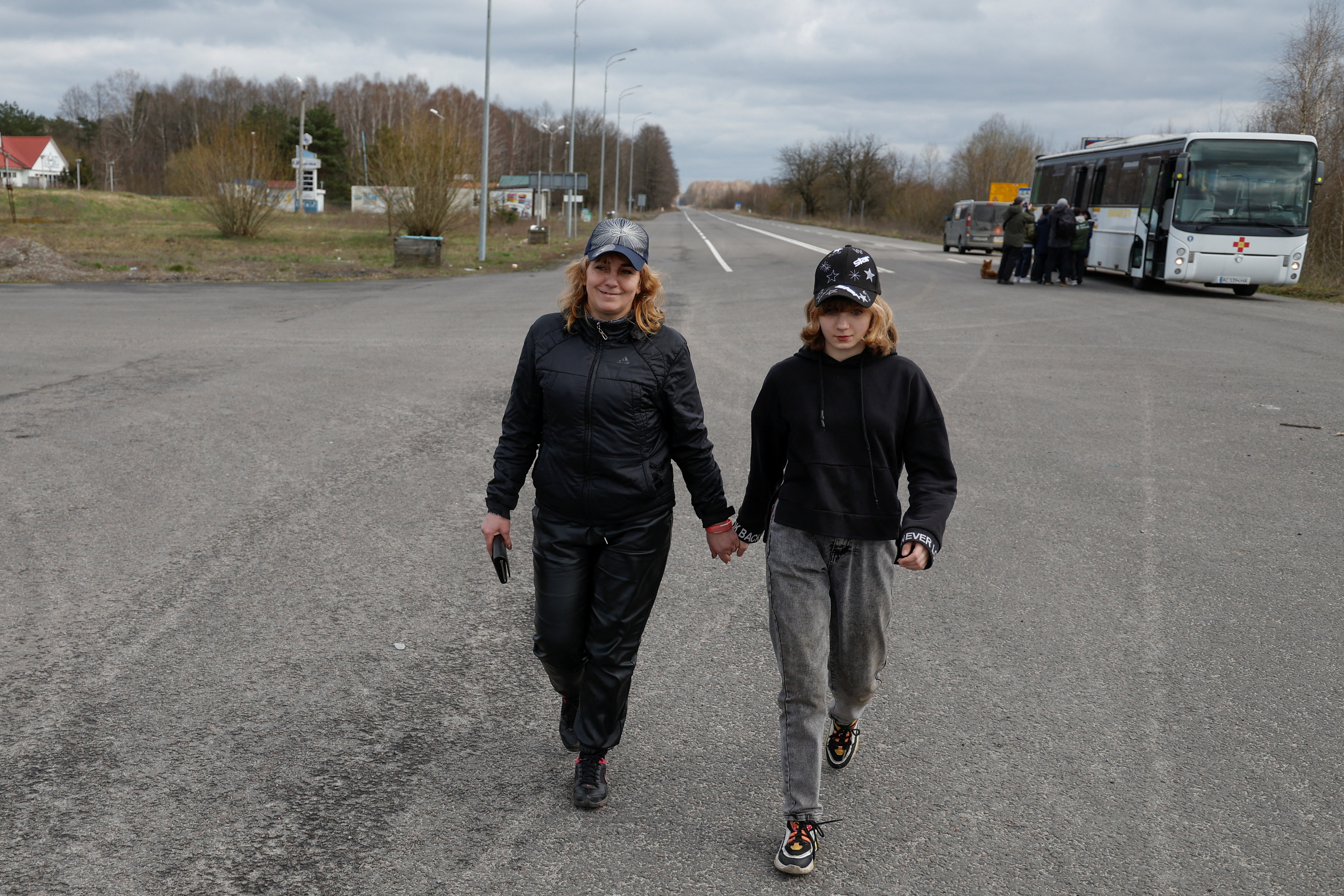 Iryna Hrinchenko smiles as she walks with her daughter Anastasiia, who was taken to Russia, after returning via the Ukraine-Belarus border, in Volyn region