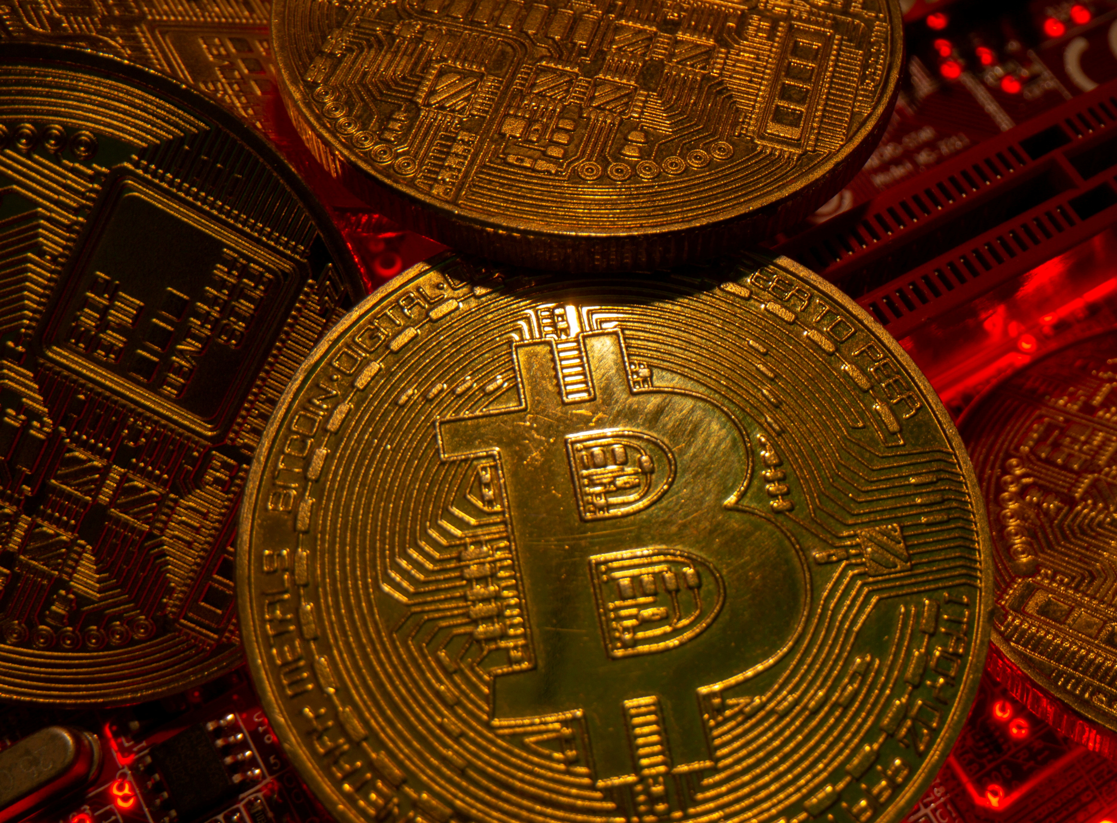 Representations of the virtual currency Bitcoin stand on a motherboard in this picture illustration taken May 20, 2021. REUTERS/Dado Ruvic/File Photo