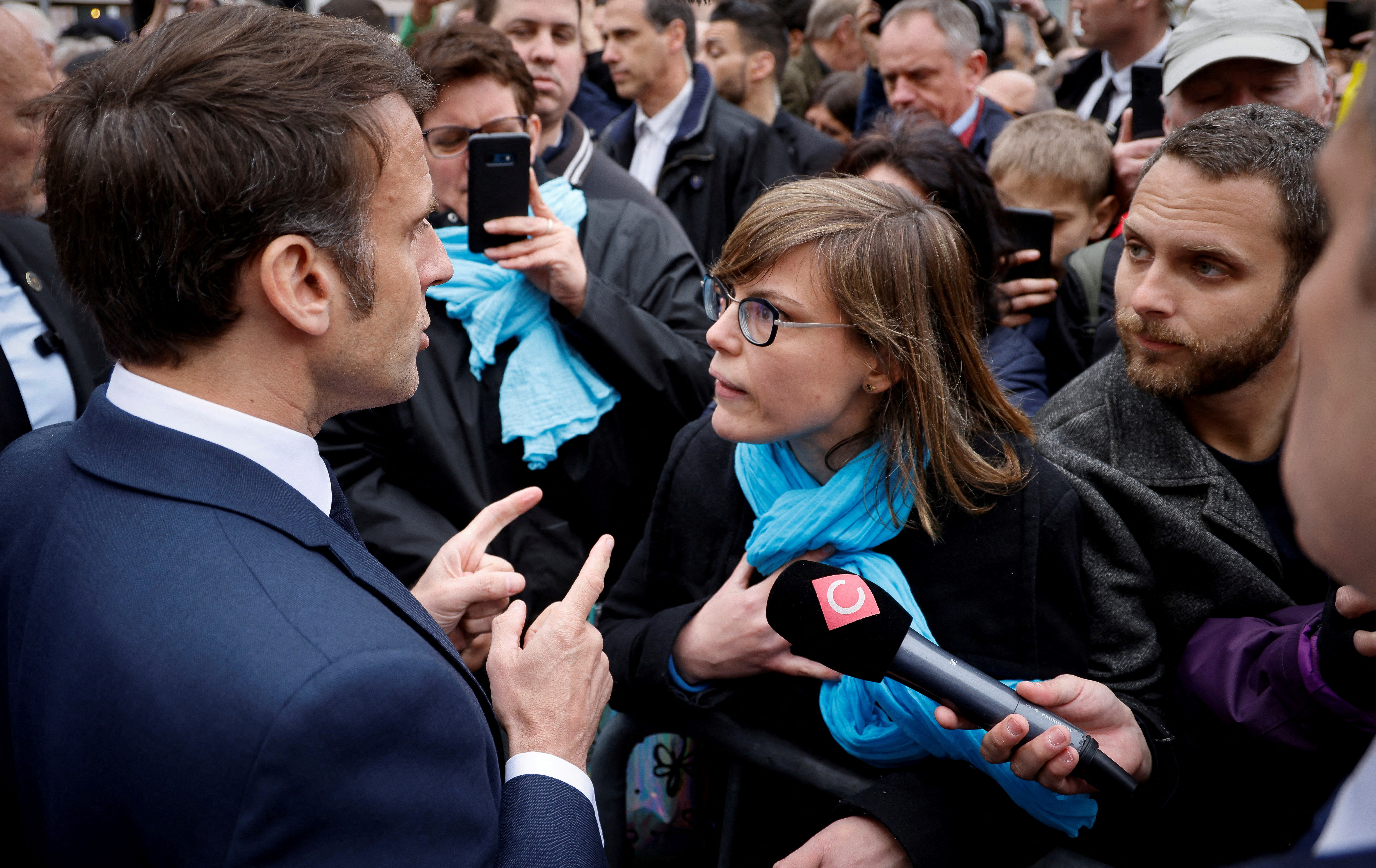 French President Emmanuel Macron talks to a person opposed to the pension reform, in Selestat