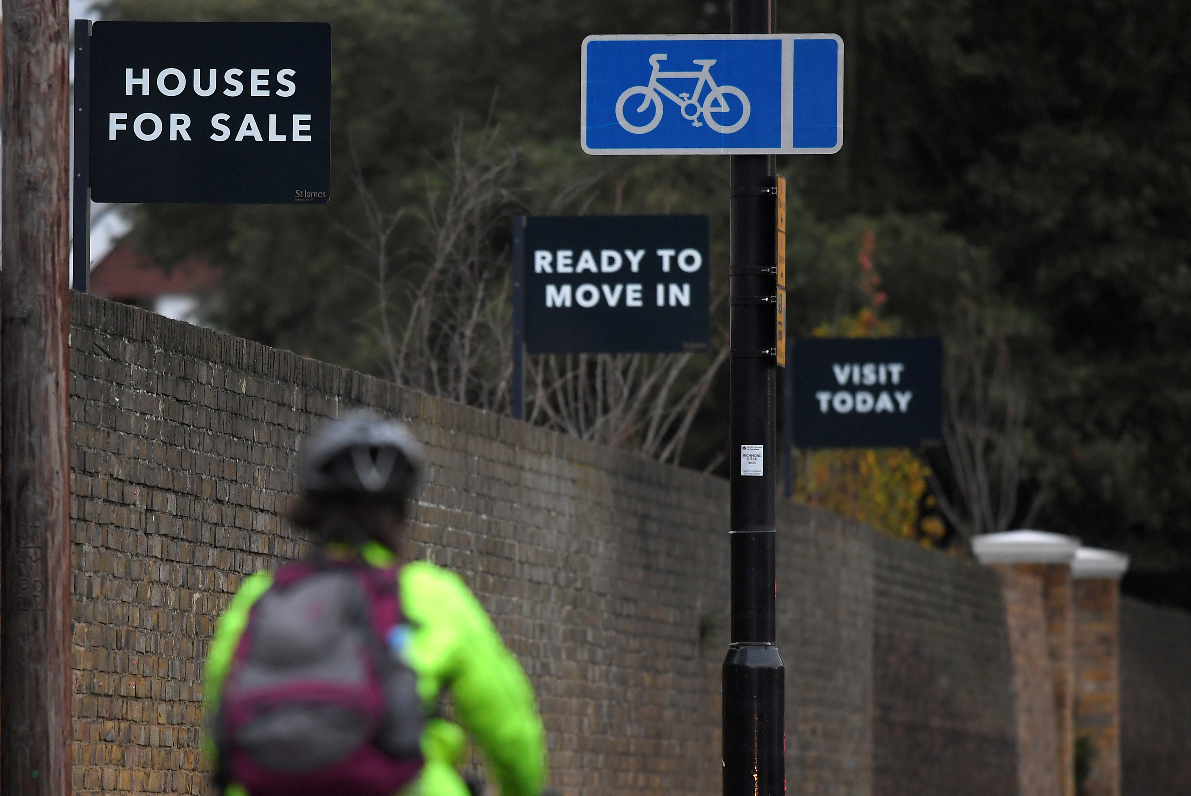 Property sale signs are seen outside of a group of newly built houses in west London