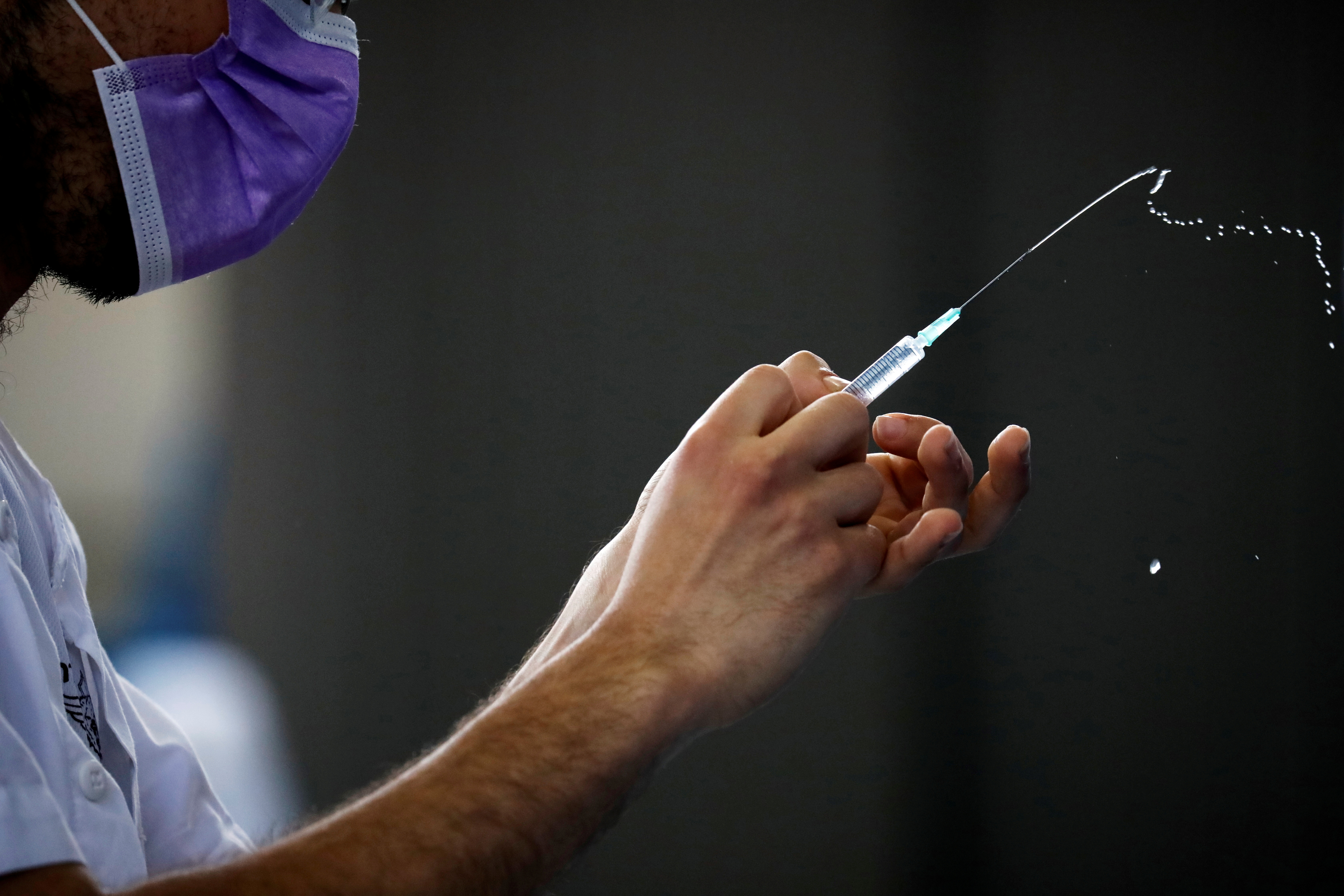 A medical worker prepares to administer a vaccination against the coronavirus disease (COVID-19) at a temporary Clalit Healthcare Maintenance Organization (HMO) centre, at a sports hall in Netivot