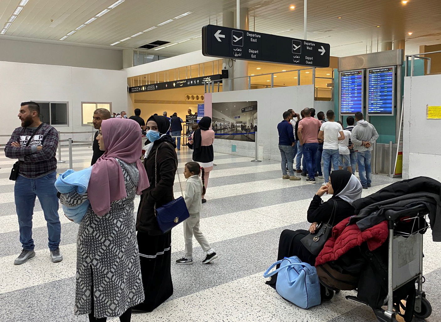 Passengers wait with their belongings at a hall at Beirut international airport in Beirut