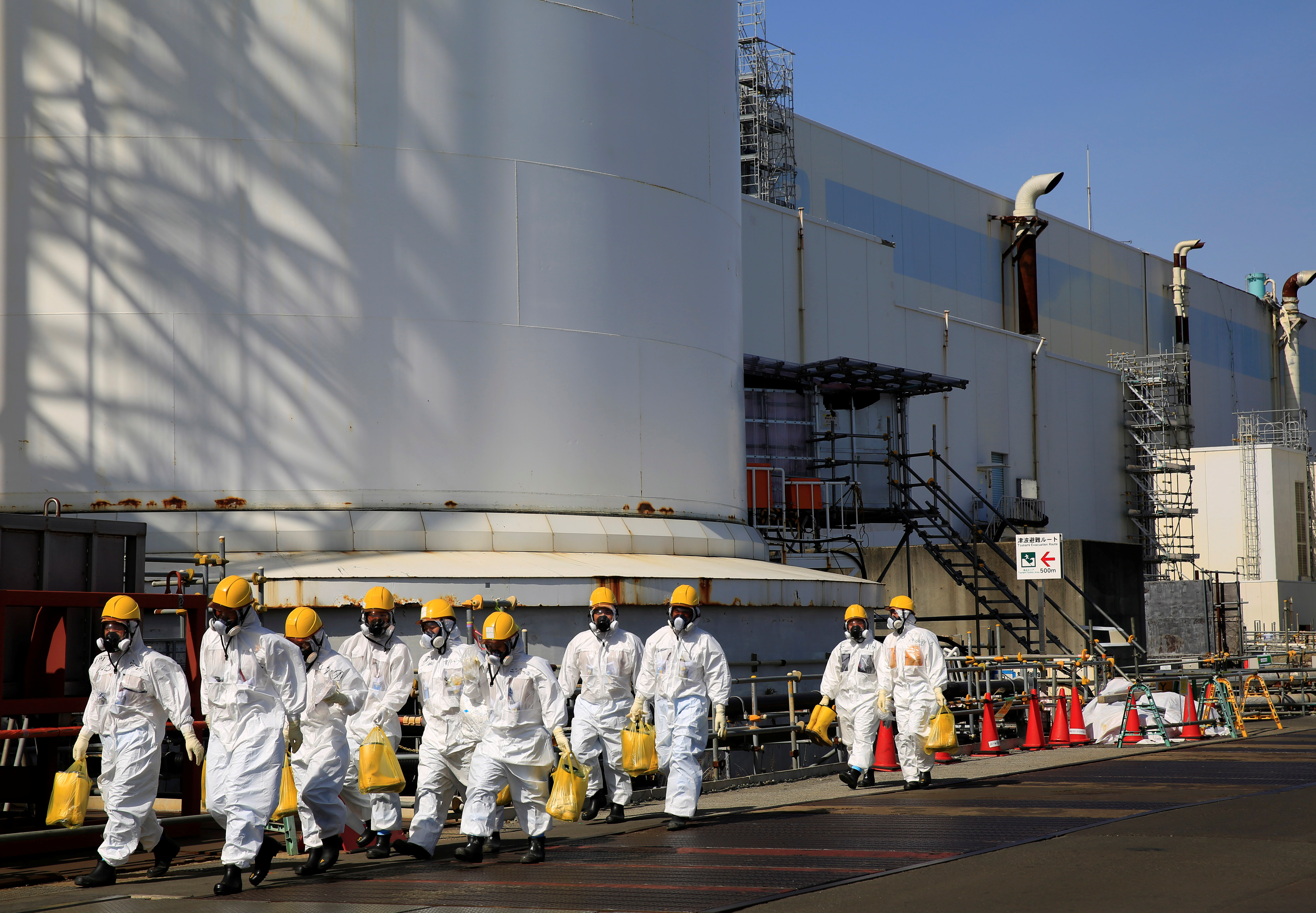 Workers walk near No. 2 and No. 3 reactor buildings at the tsunami-crippled Fukushima Daiichi nuclear power plant in Okuma town