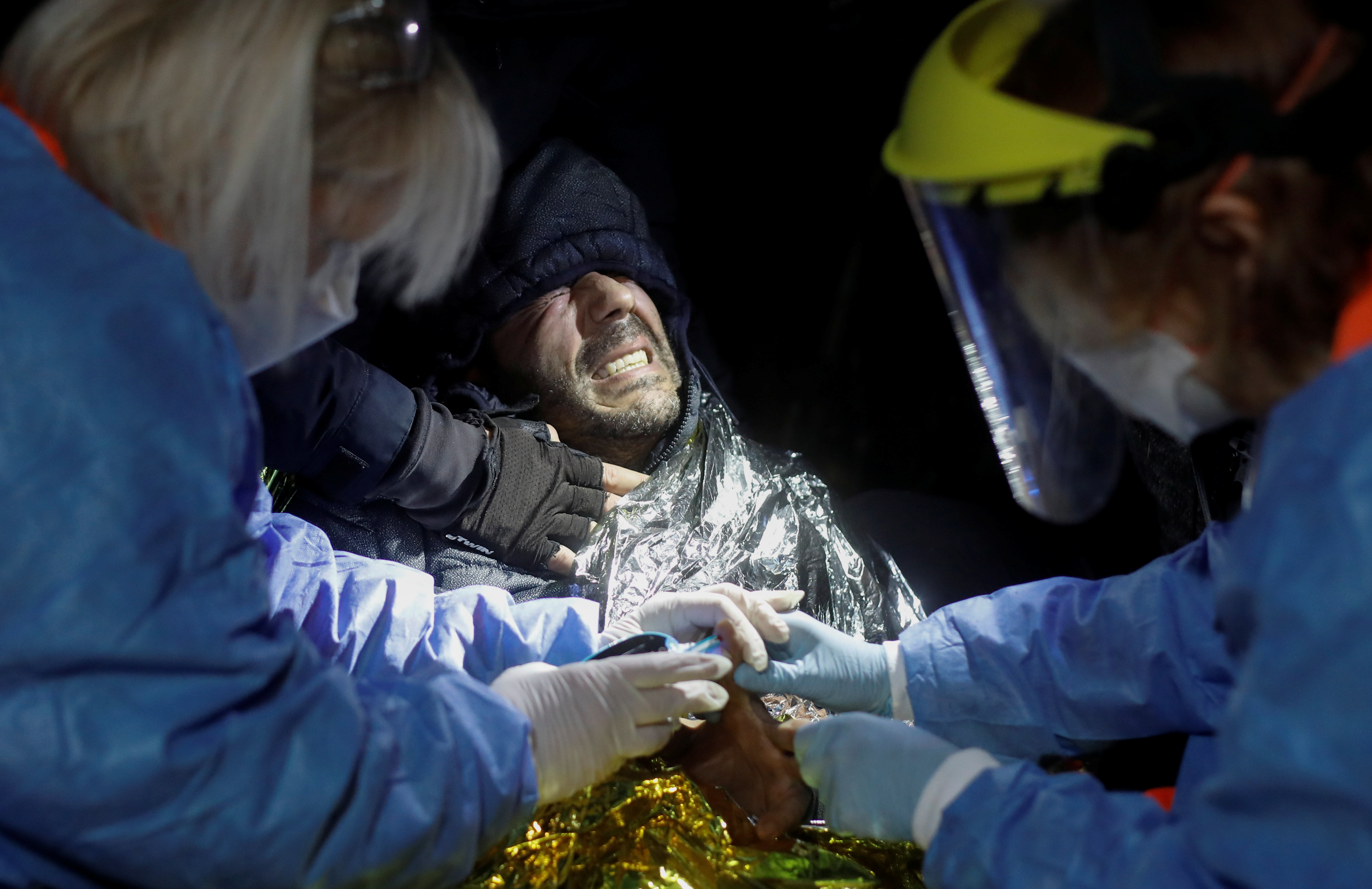 Kader, 39, a Syrian migrant from Homs, is rescued by medical workers during the migrant crisis at the Belarusian-Polish border, near Topczykaly, Poland, November 14, 2021. REUTERS/Kacper Pempel
