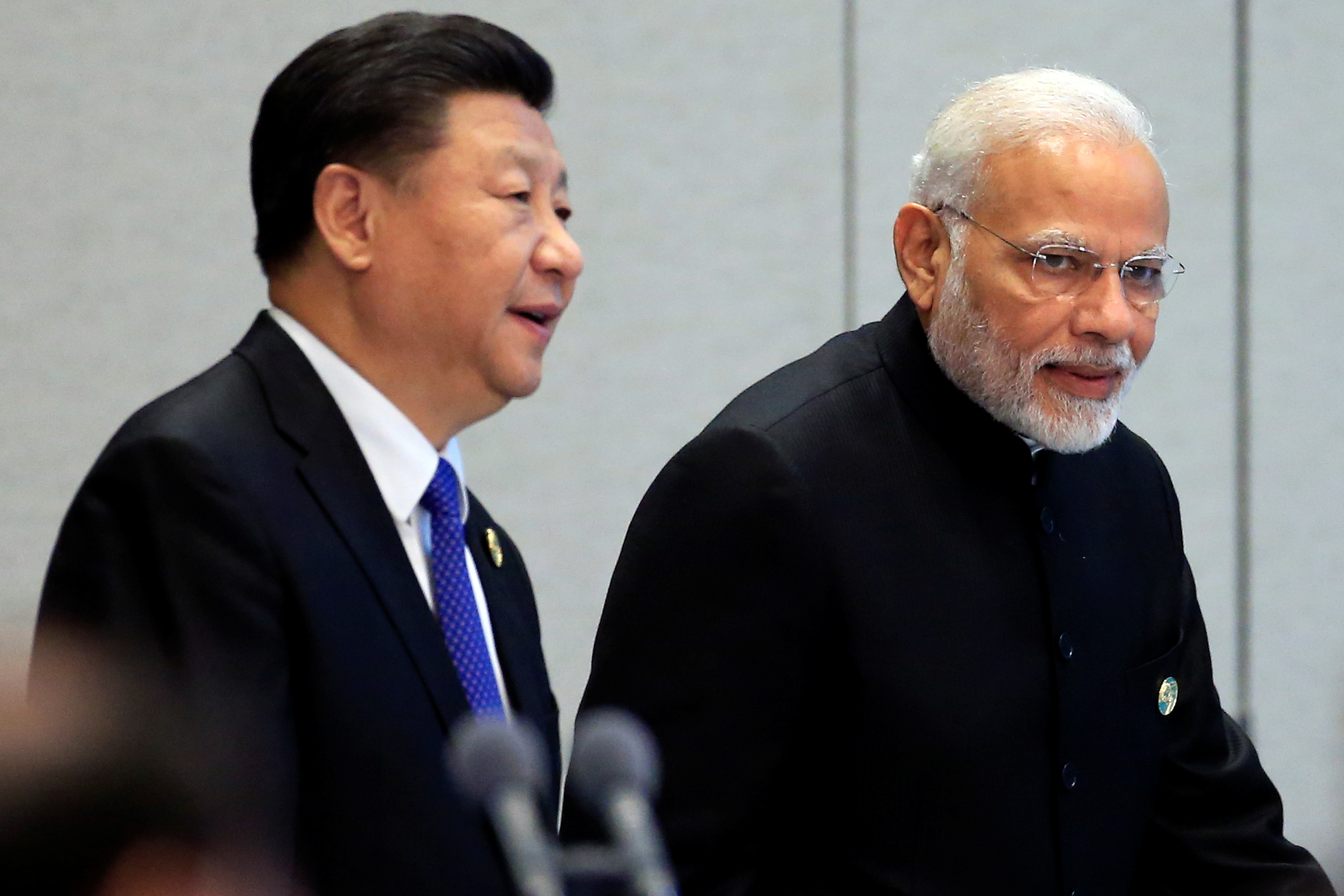 China's President Xi Jinping and India's Prime Minister Narendra Modi arrive for a signing ceremony during Shanghai Cooperation Organization (SCO) summit in Qingdao