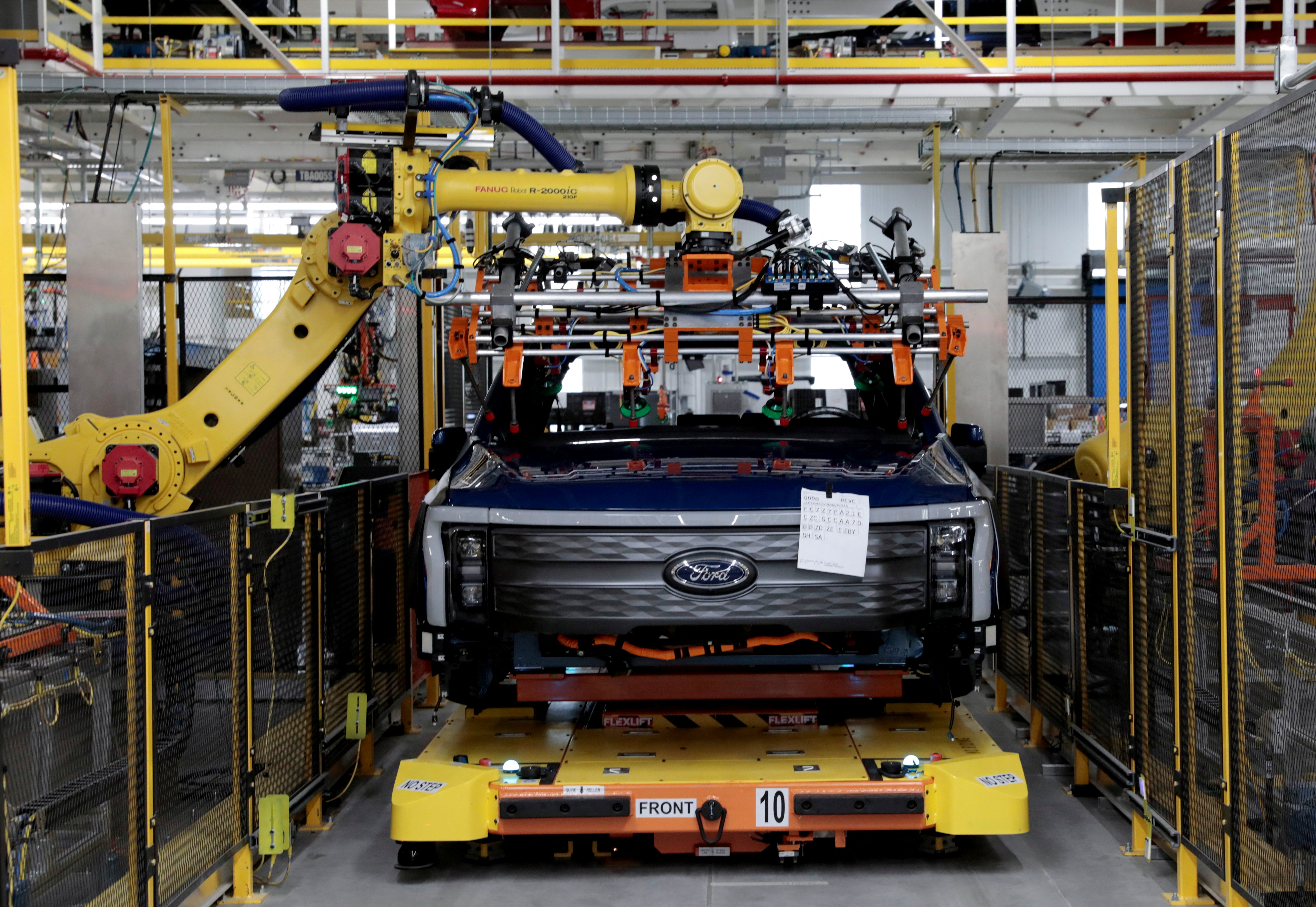 A robot works on a Ford pre-production all-electric F-150 Lightning truck prototype at the Rouge Electric Vehicle Center in Dearborn, Michigan, U.S. September 16, 2021.   REUTERS/Rebecca Cook/File Photo