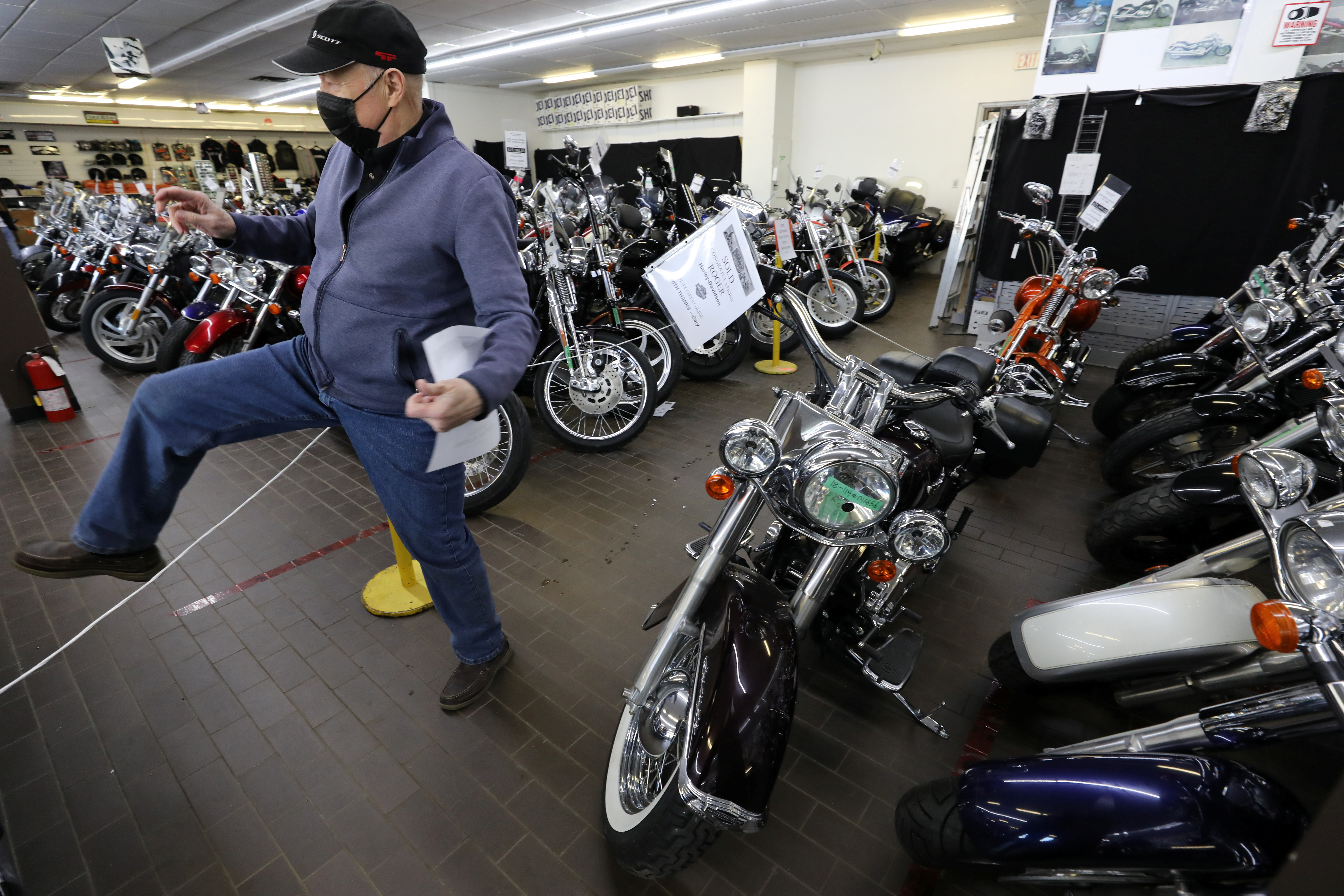 Gary Haines places SOLD signs on Harley Davidson motorcycles in Toronto