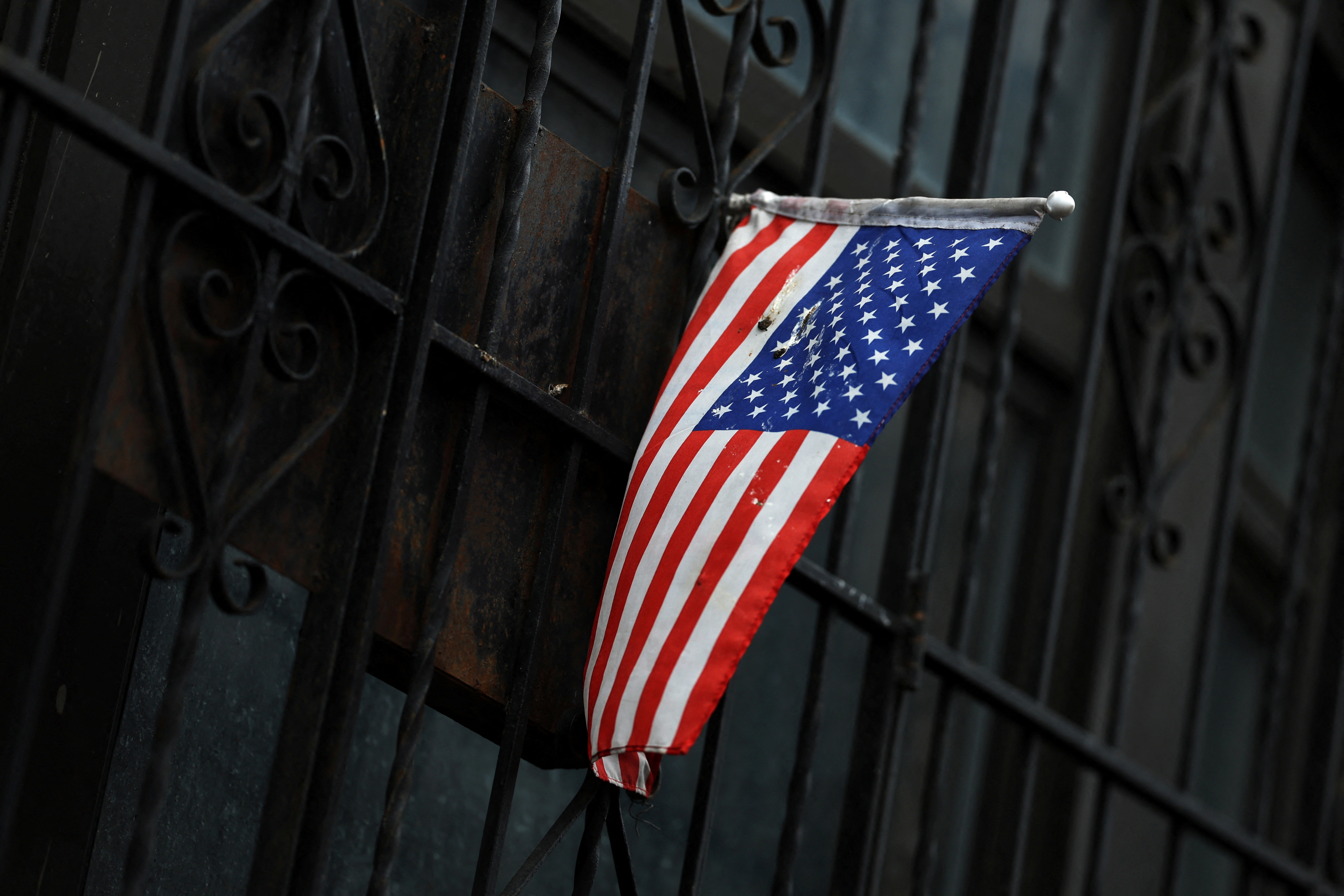 A U.S. flag hangs out the gated entrance to an apartment in the Washington Heights neighborhood of the borough of Manhattan in New York City
