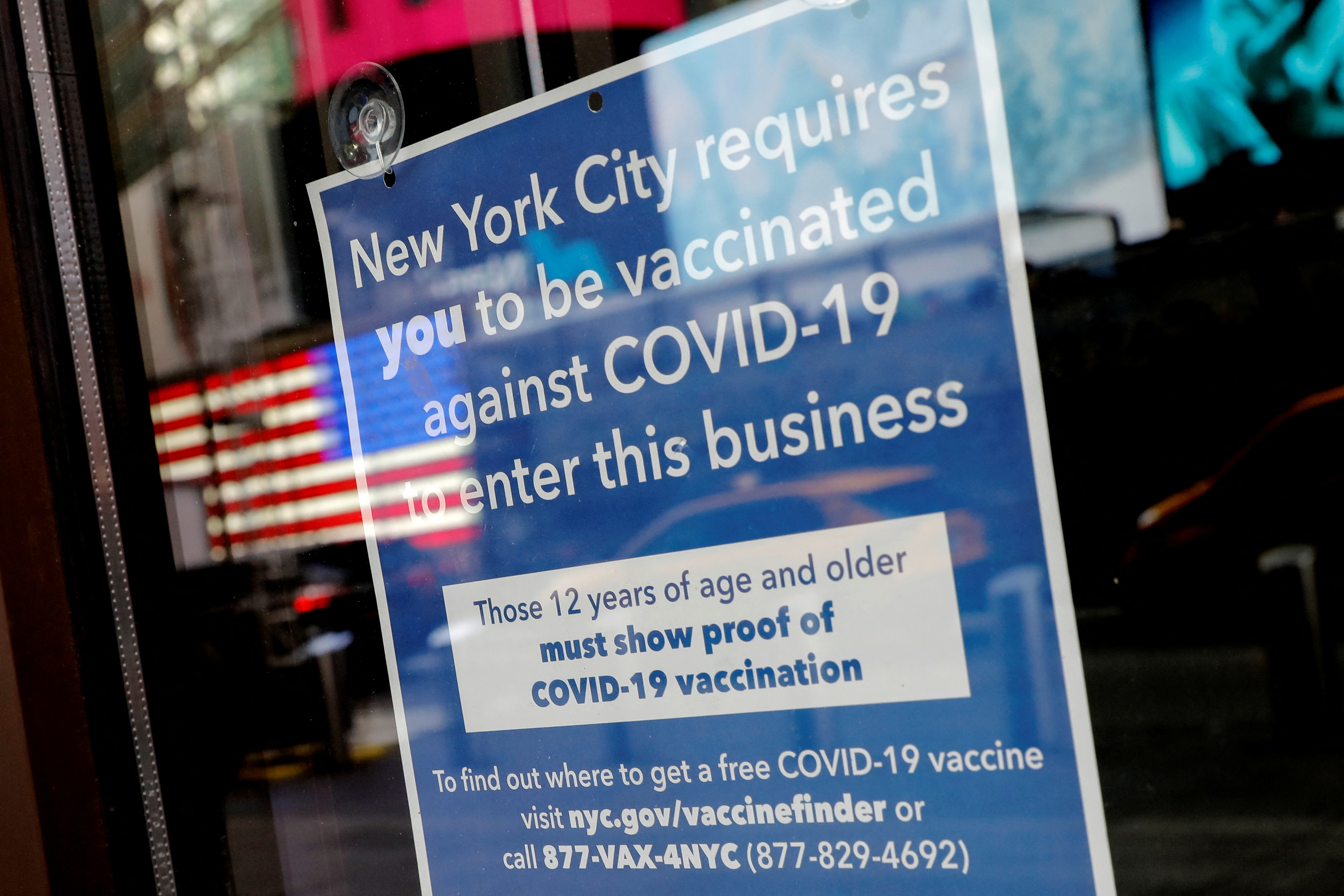 A sign is pictured on the door of a restaurant requiring patrons to be vaccinated against COVID-19 in Times Square in Manhattan New York City, New York, U.S., December 7, 2021. REUTERS/Mike Segar