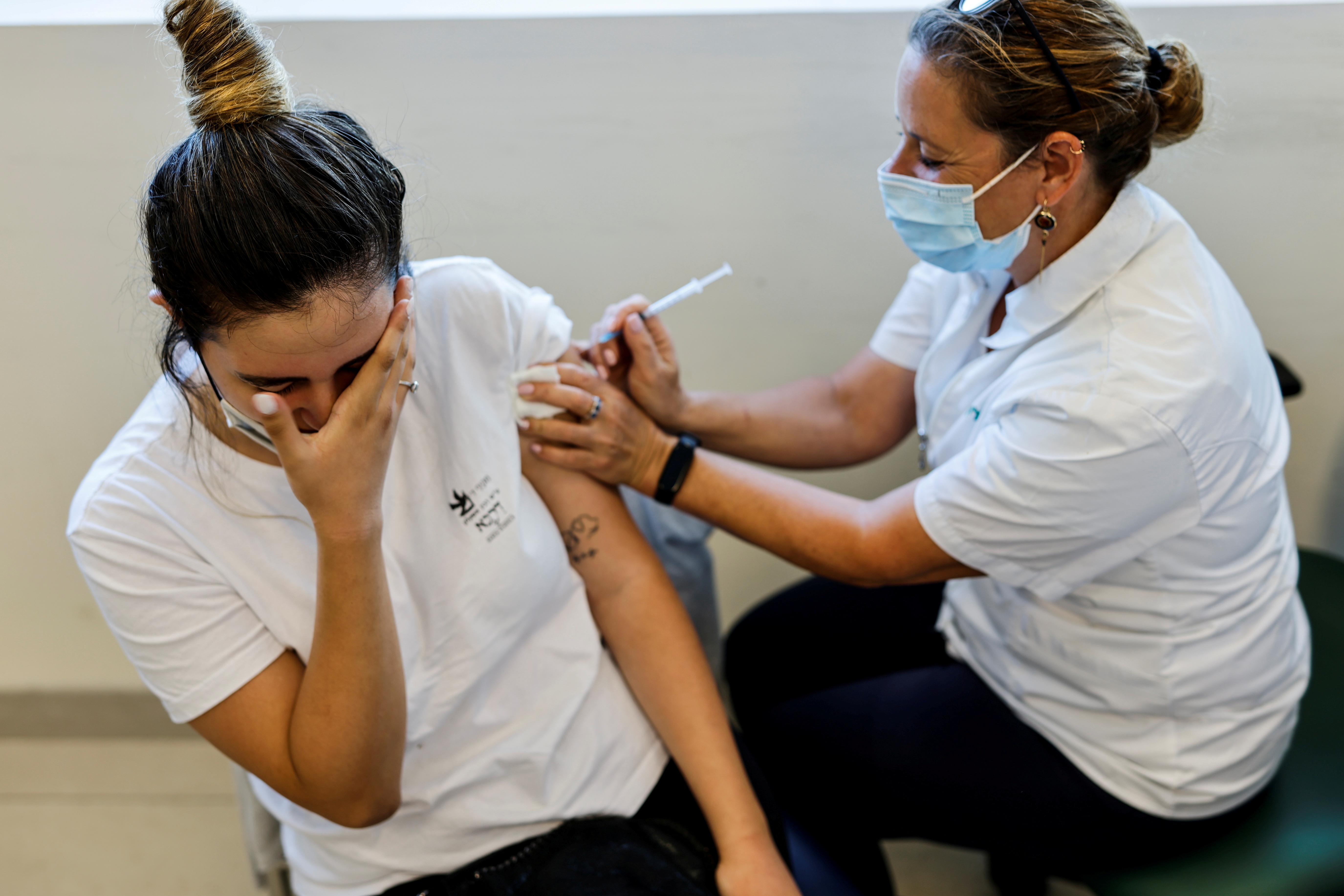 A teenager receives a dose of a vaccine against the coronavirus disease (COVID-19) after Israel approved the usage of the vaccine for youngsters aged 12-15, at a Clalit healthcare maintenance organisation in Ashkelon, Israel June 6, 2021. REUTERS/Amir Cohen/File Photo