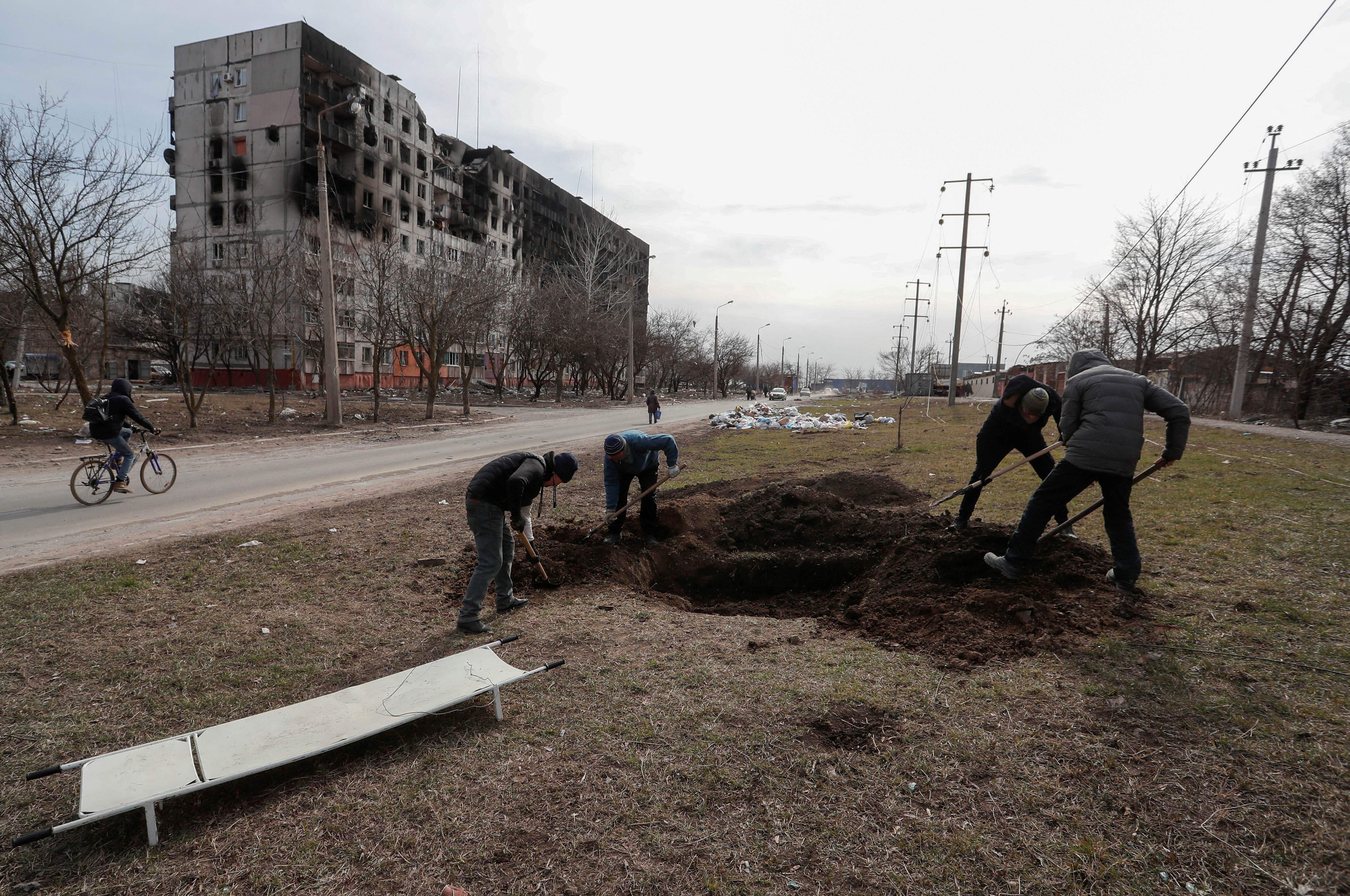People dig a grave in the besieged city of Mariupol