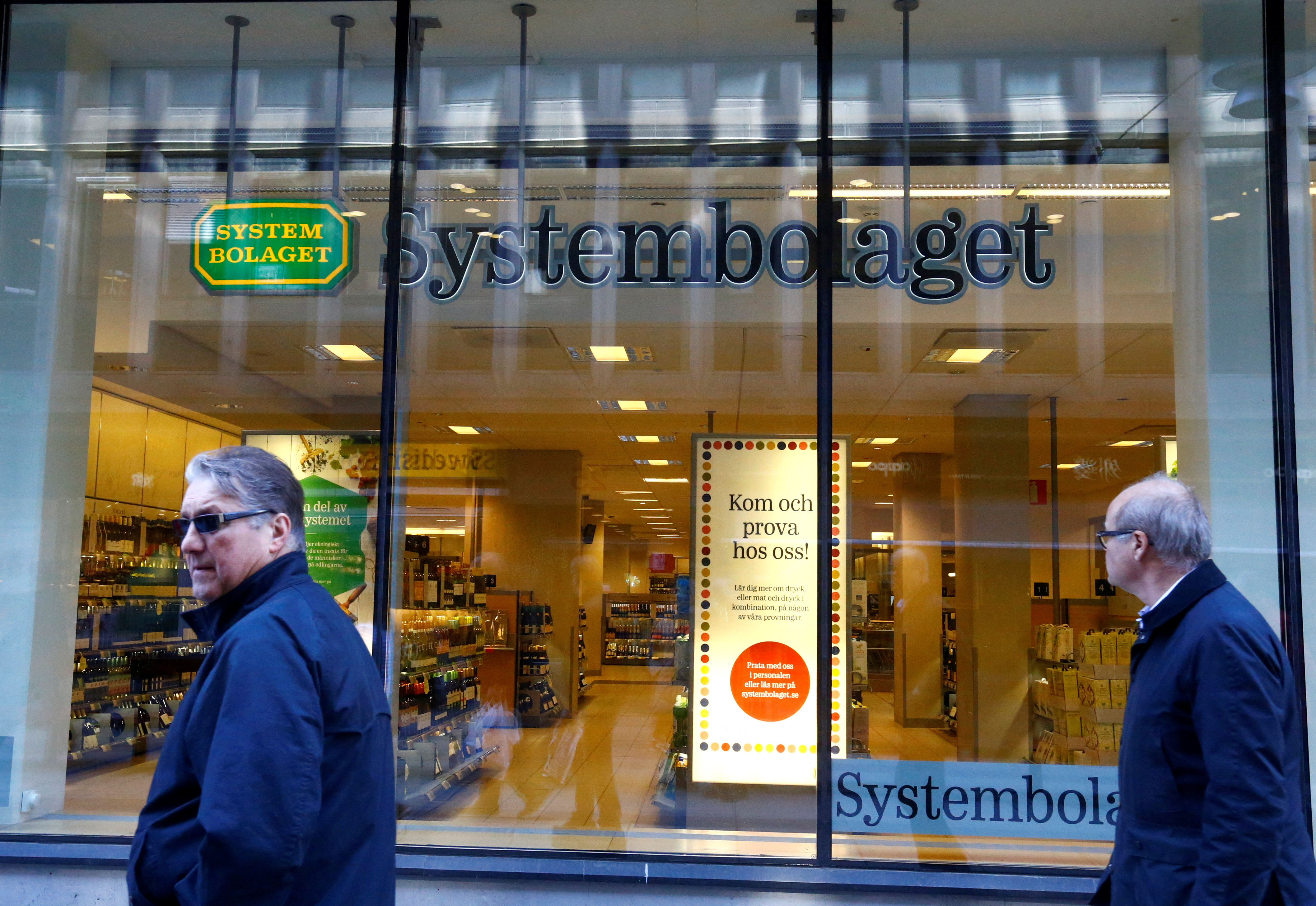 People walk past Systembolaget in Stockholm