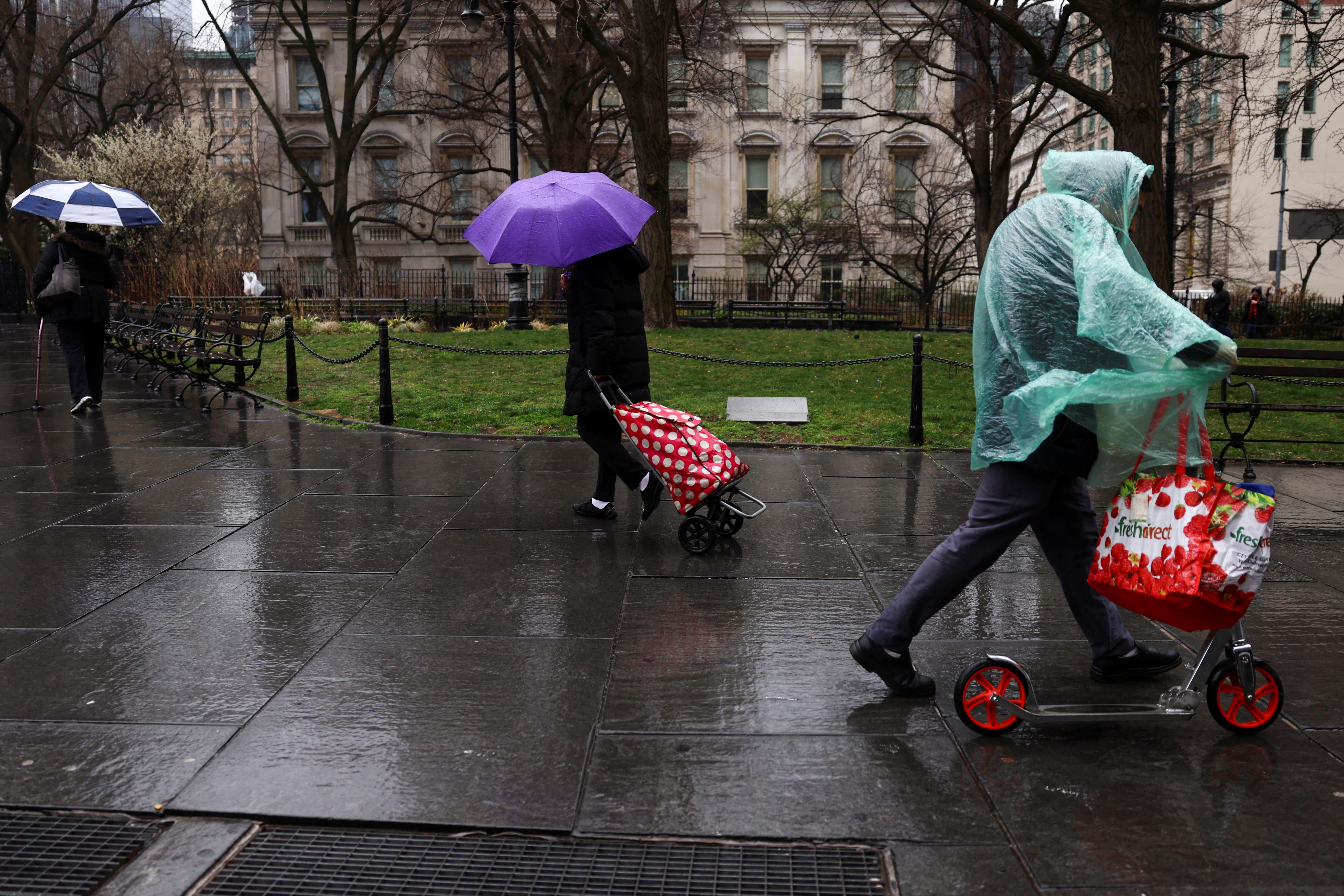 People walk under the rain near Foley Square and Manhattan Criminal Court, in New York City