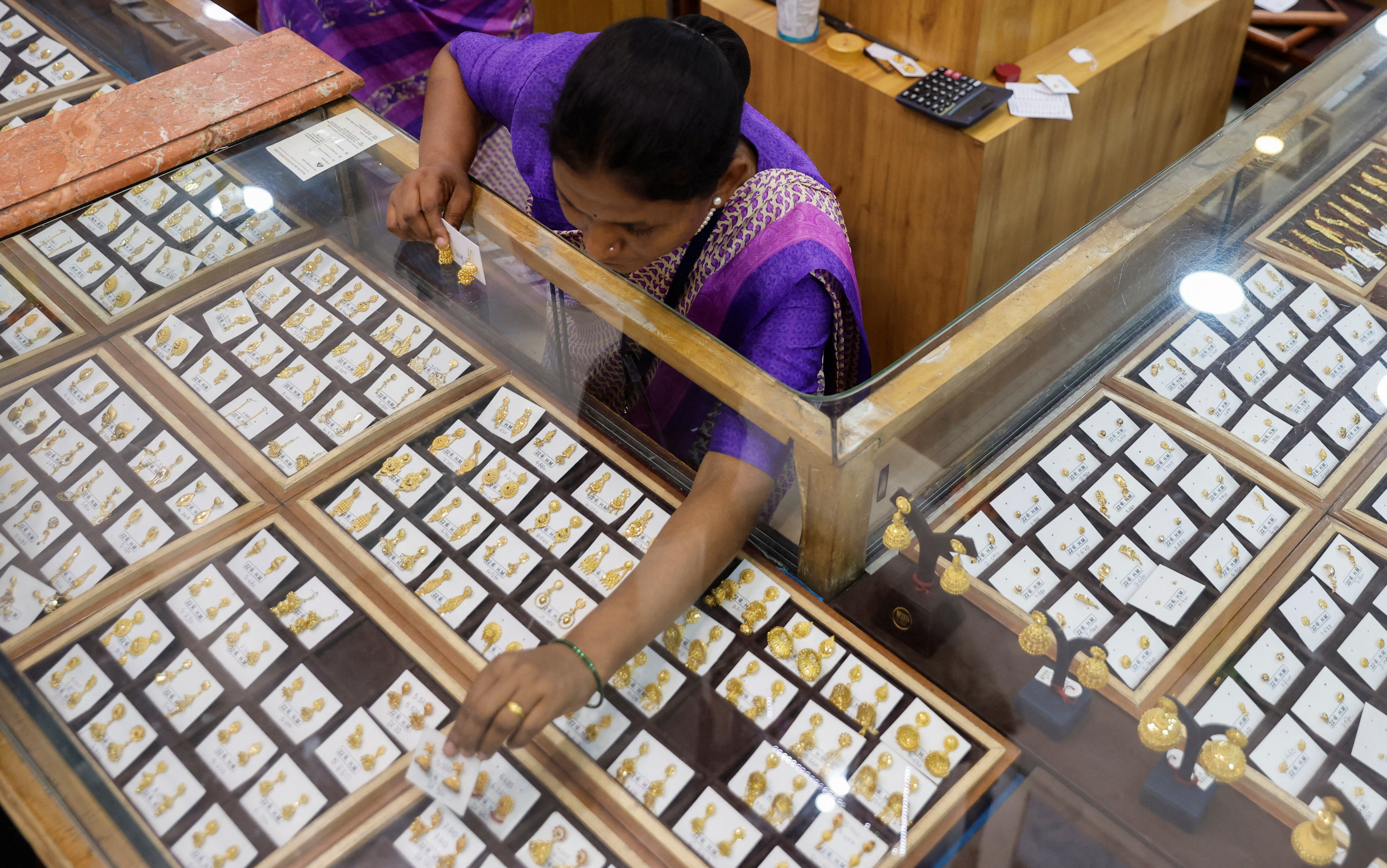 A saleswoman arranges earrings at a jewellery showroom during Dhanteras, in Mumbai