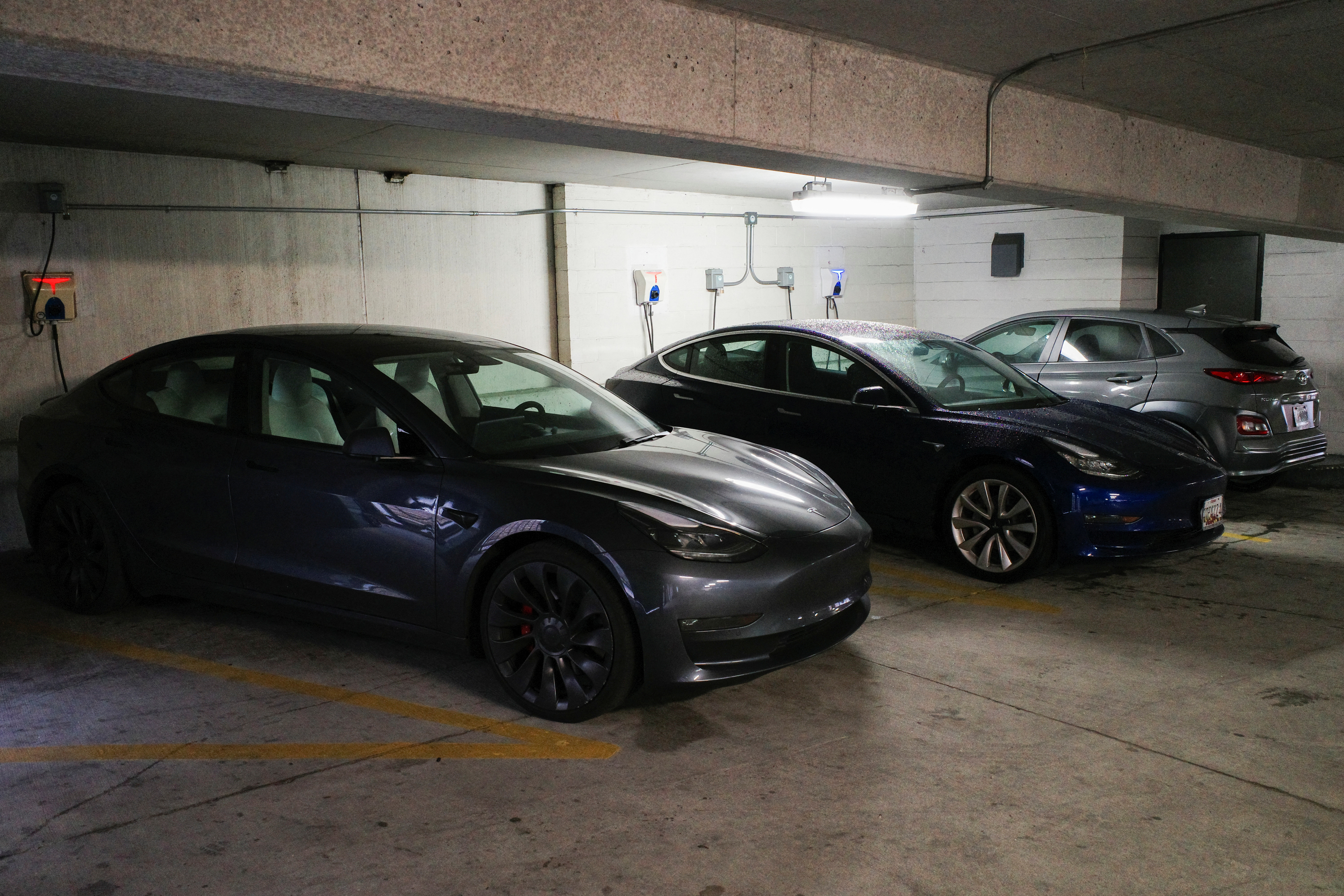 Tesla and Hyundai electric vehicles charge at EV charging stations