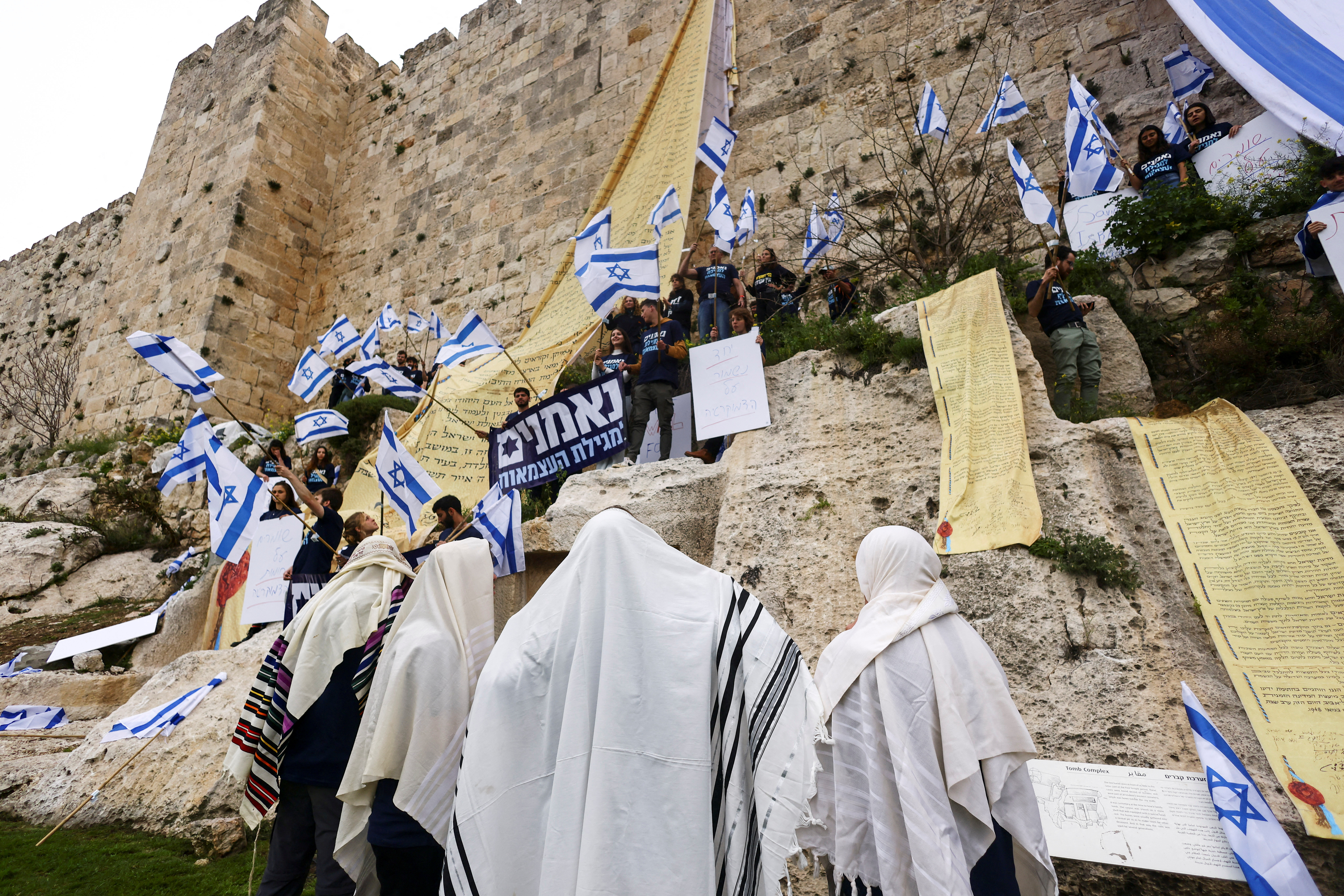 Demonstrators hang flags on the walls of Jerusalem's Old City in an act of protest as Israelis launch 