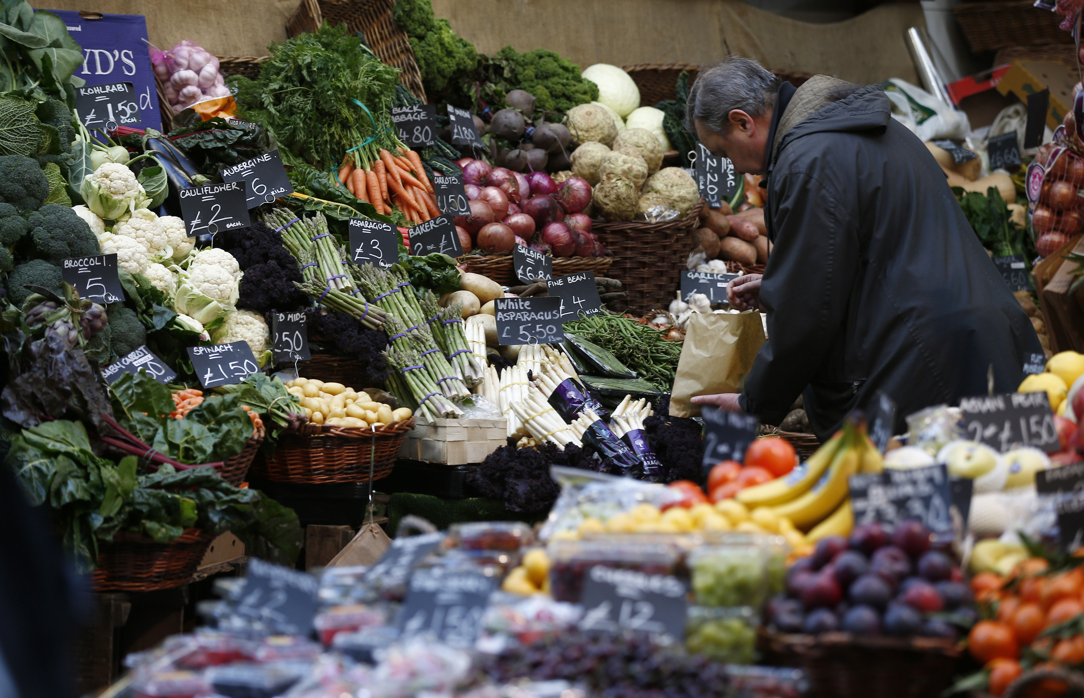 A shopper browses at a vegetable market, in London