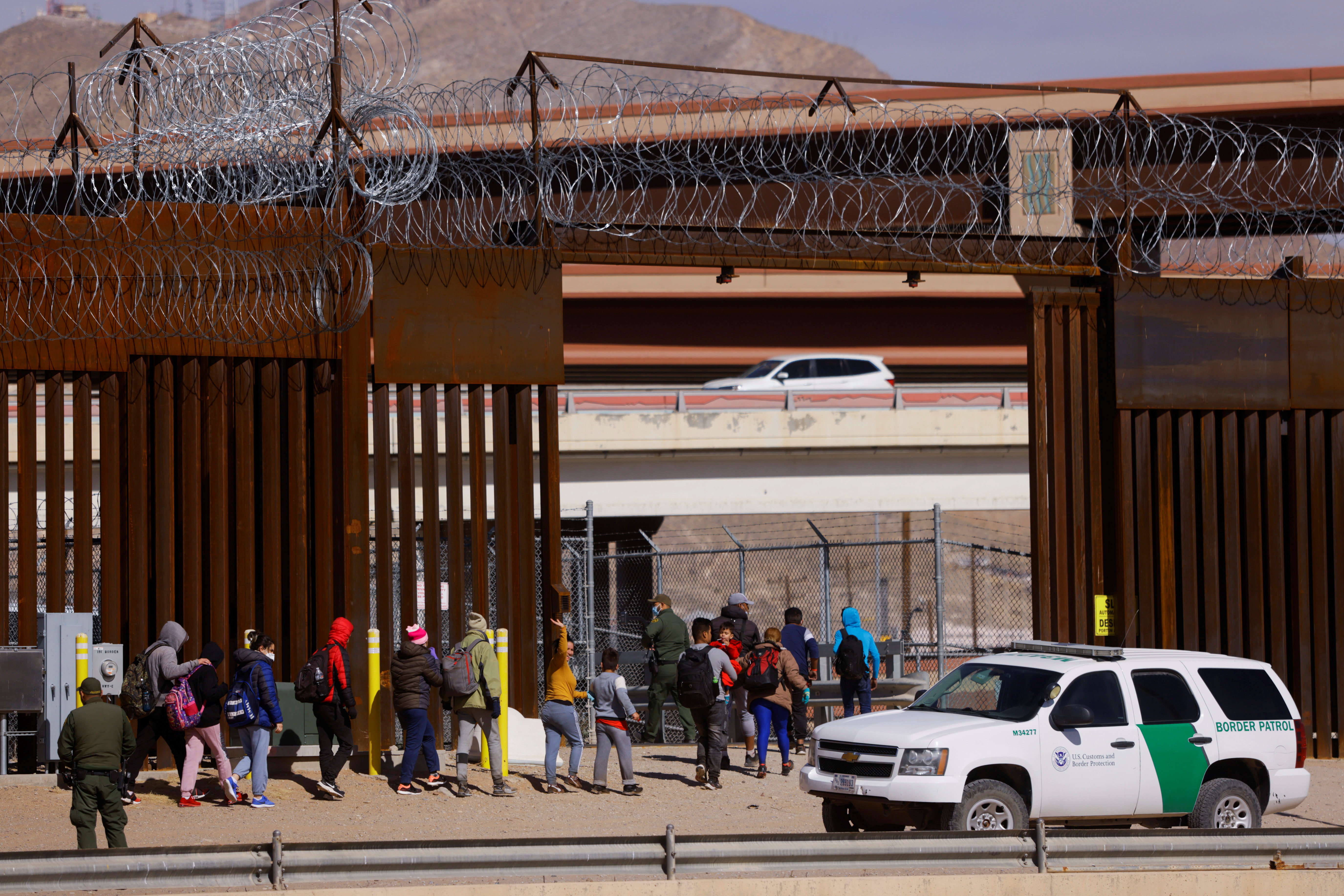 Migrants are detained by U.S. Border Patrol agents, as seen from Ciudad Juarez