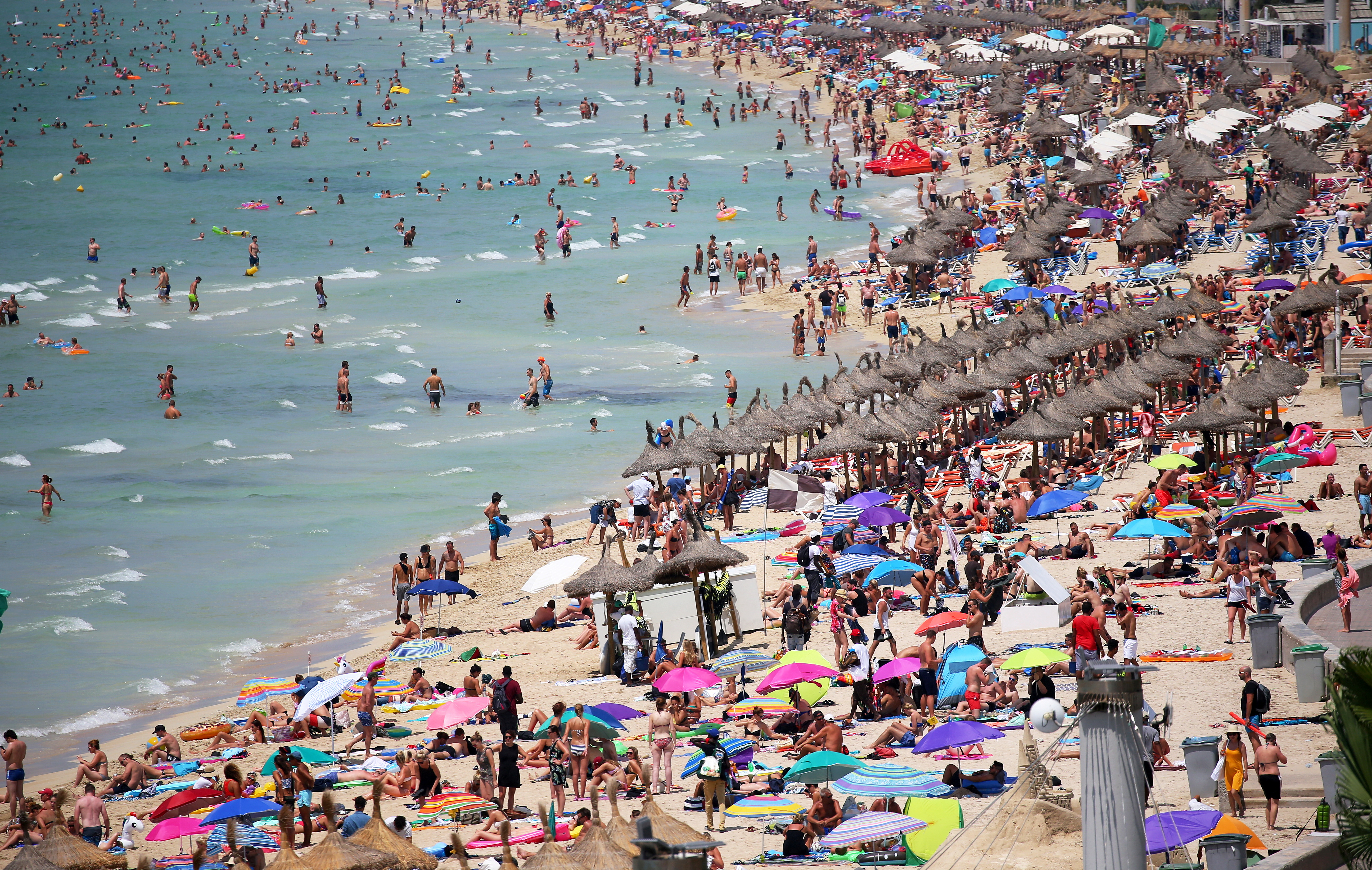 Pre-pandemic tourists sunbathe in El Arenal beach in the island of Mallorca