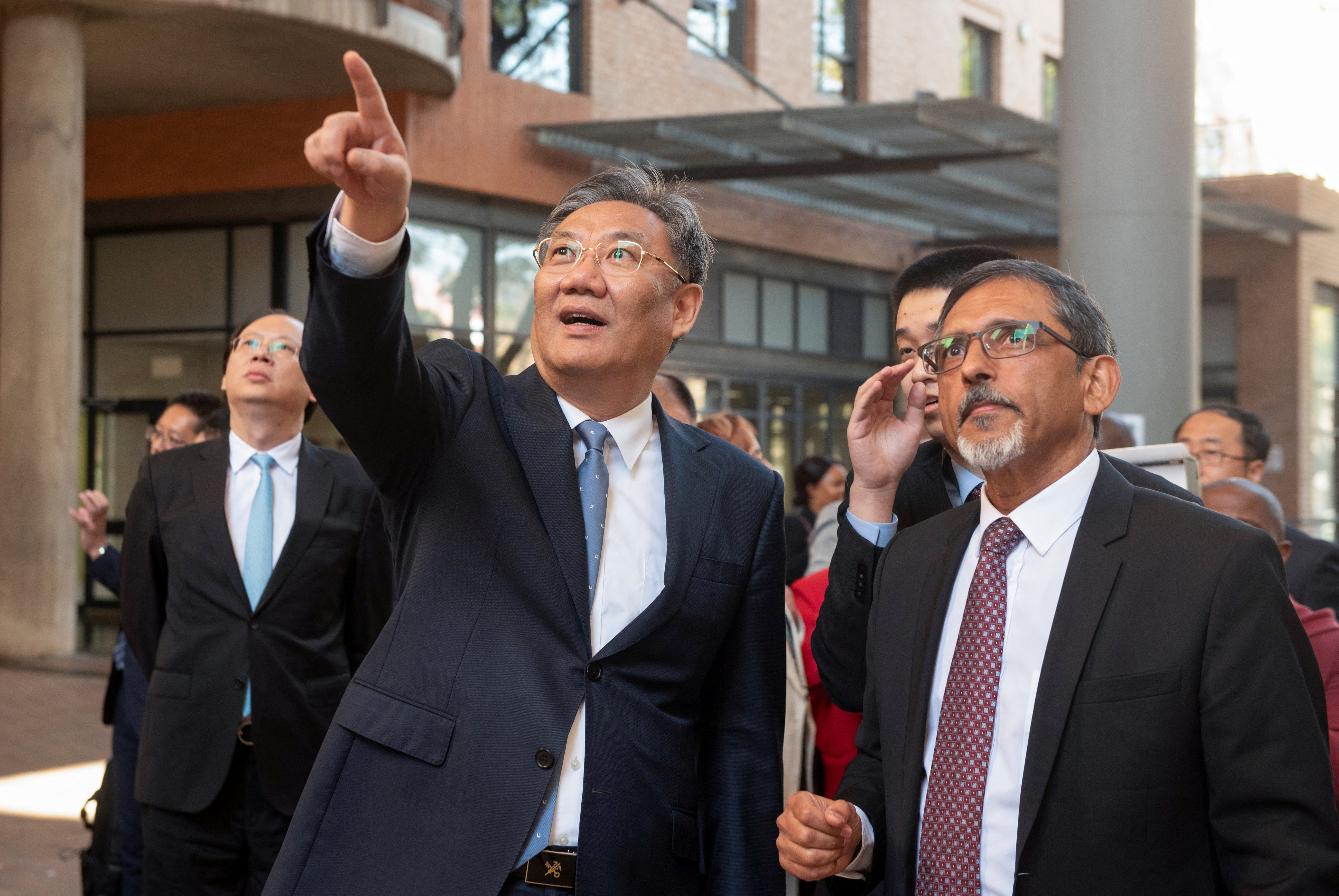 China's Minister of Commerce Wang Wentao gestures as South Africa's Minister of Trade, Industry and Competition Ebrahim Patel shows him the Department of Trade, Industry, and Competition's campus in Pretoria