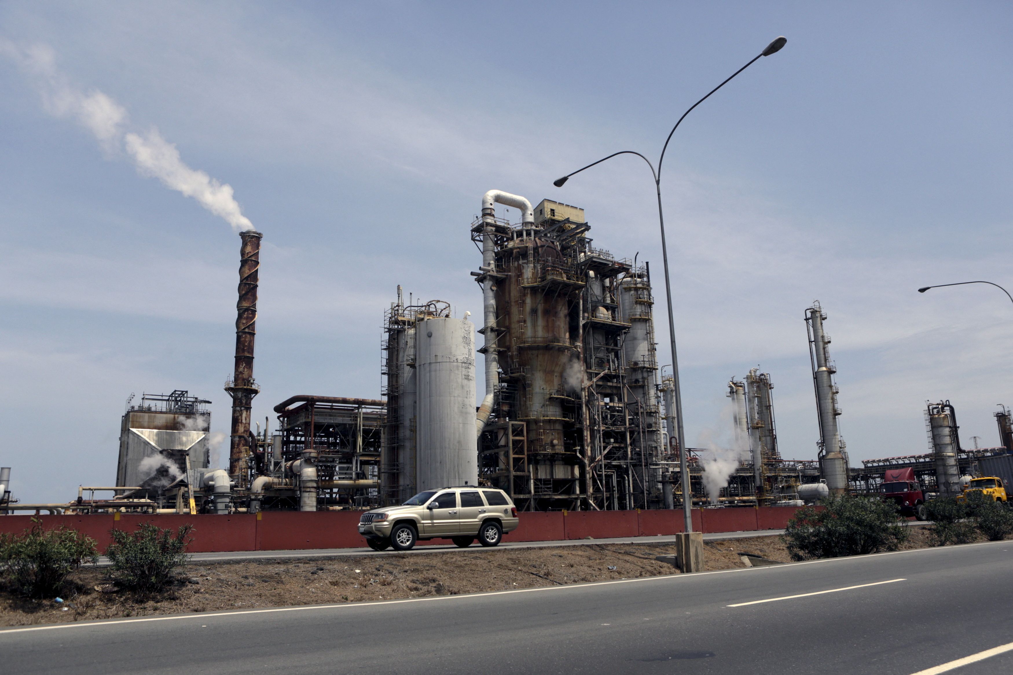 A car drives past El Palito refinery which belongs to PDVSA in Puerto Cabello