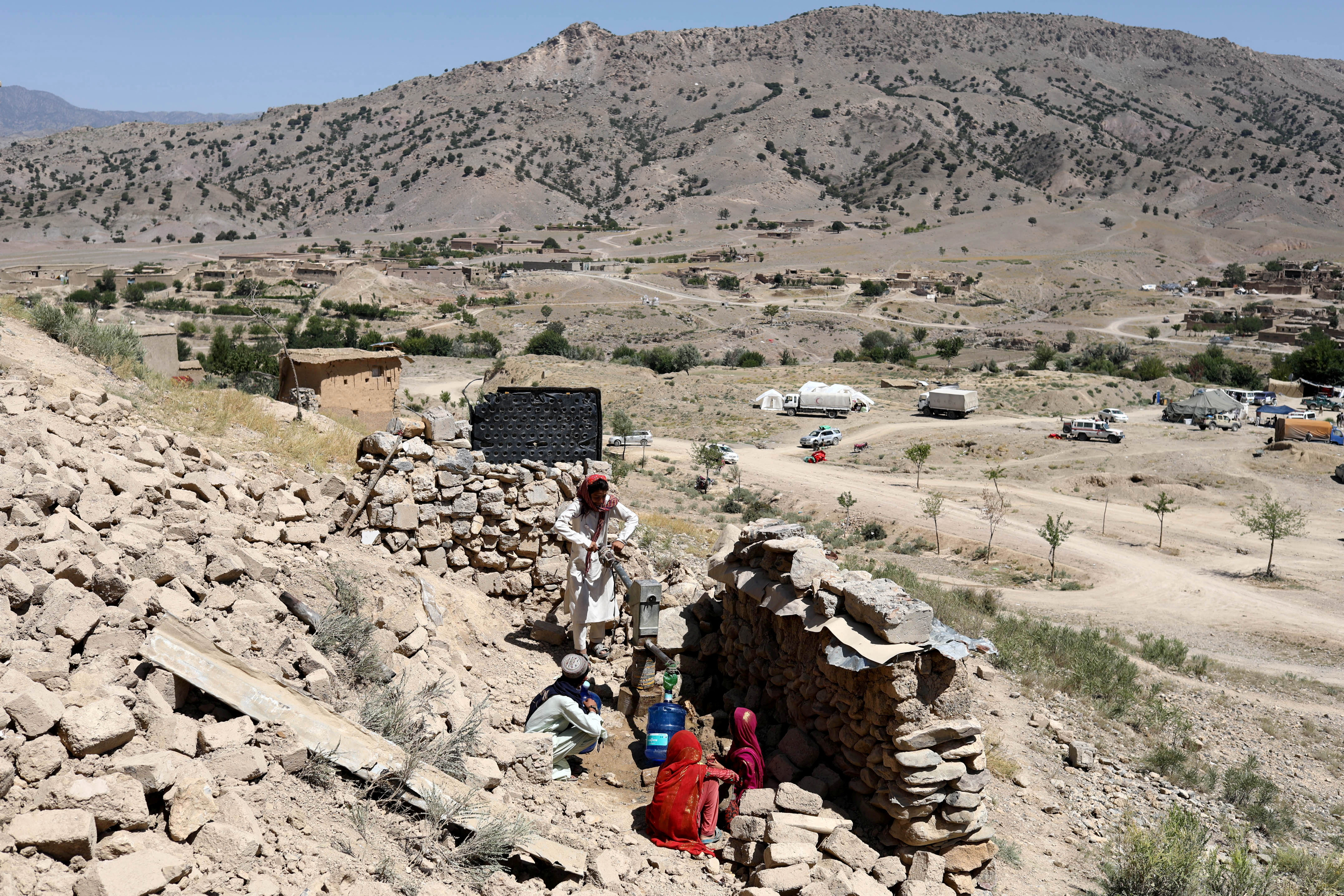 Afghan people collect water after the recent earthquake in Wor Kali village