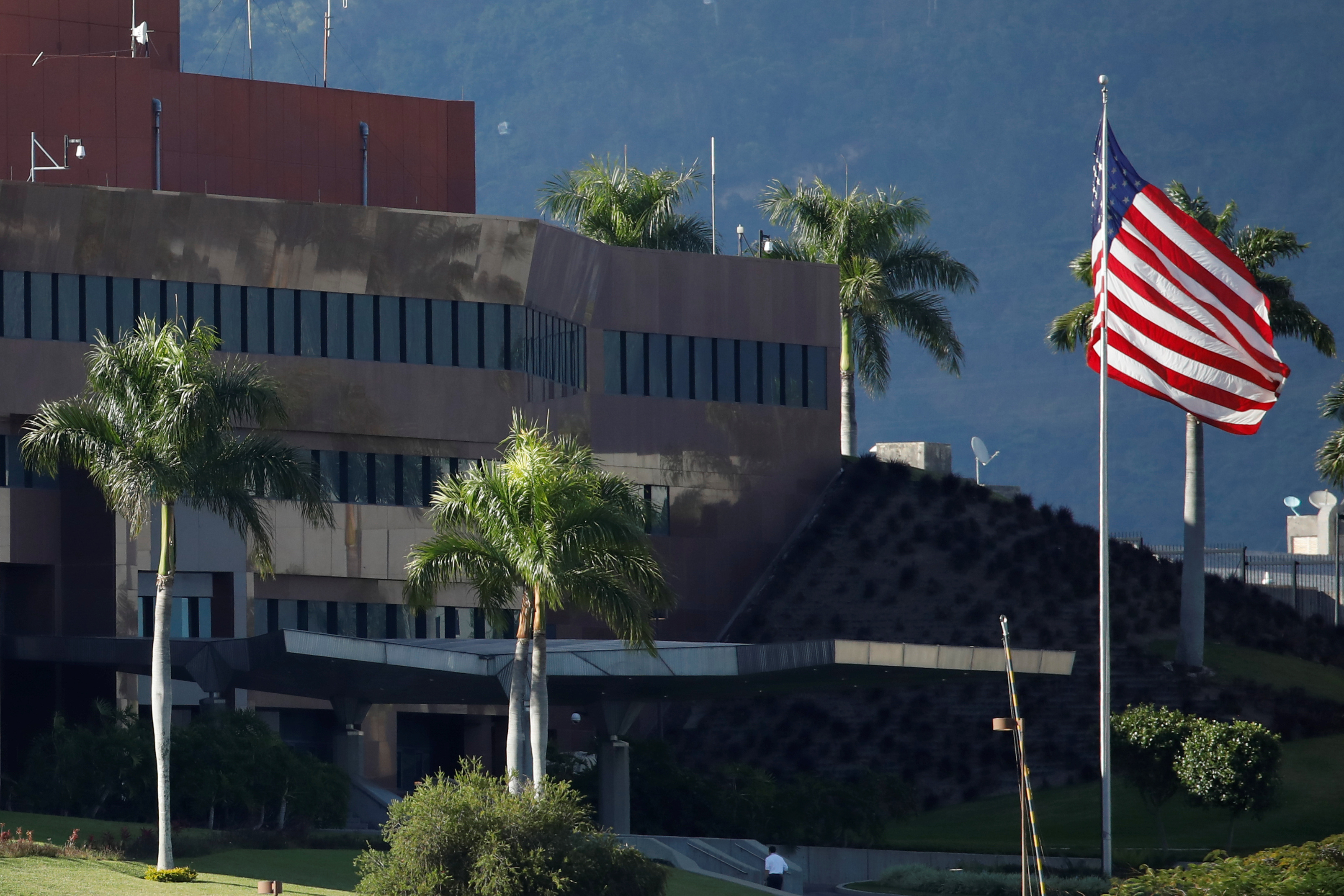 A man walks next to a U.S. flag at the U.S. Embassy in Caracas