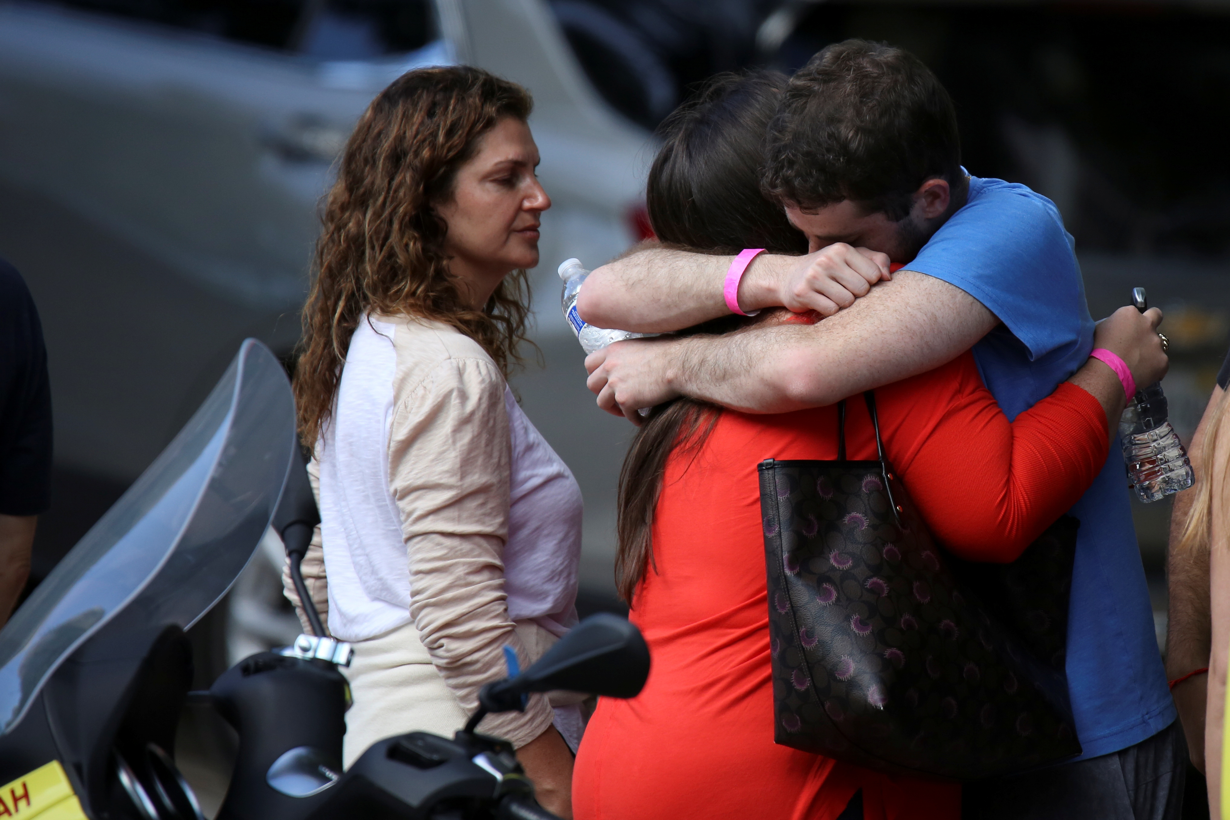Family members of those reported missing embrace each other at the entrance of a hotel after visiting the site of a partially collapsed residential building in Surfside, near Miami Beach, Florida, U.S. June 27, 2021. REUTERS/Marco Bello