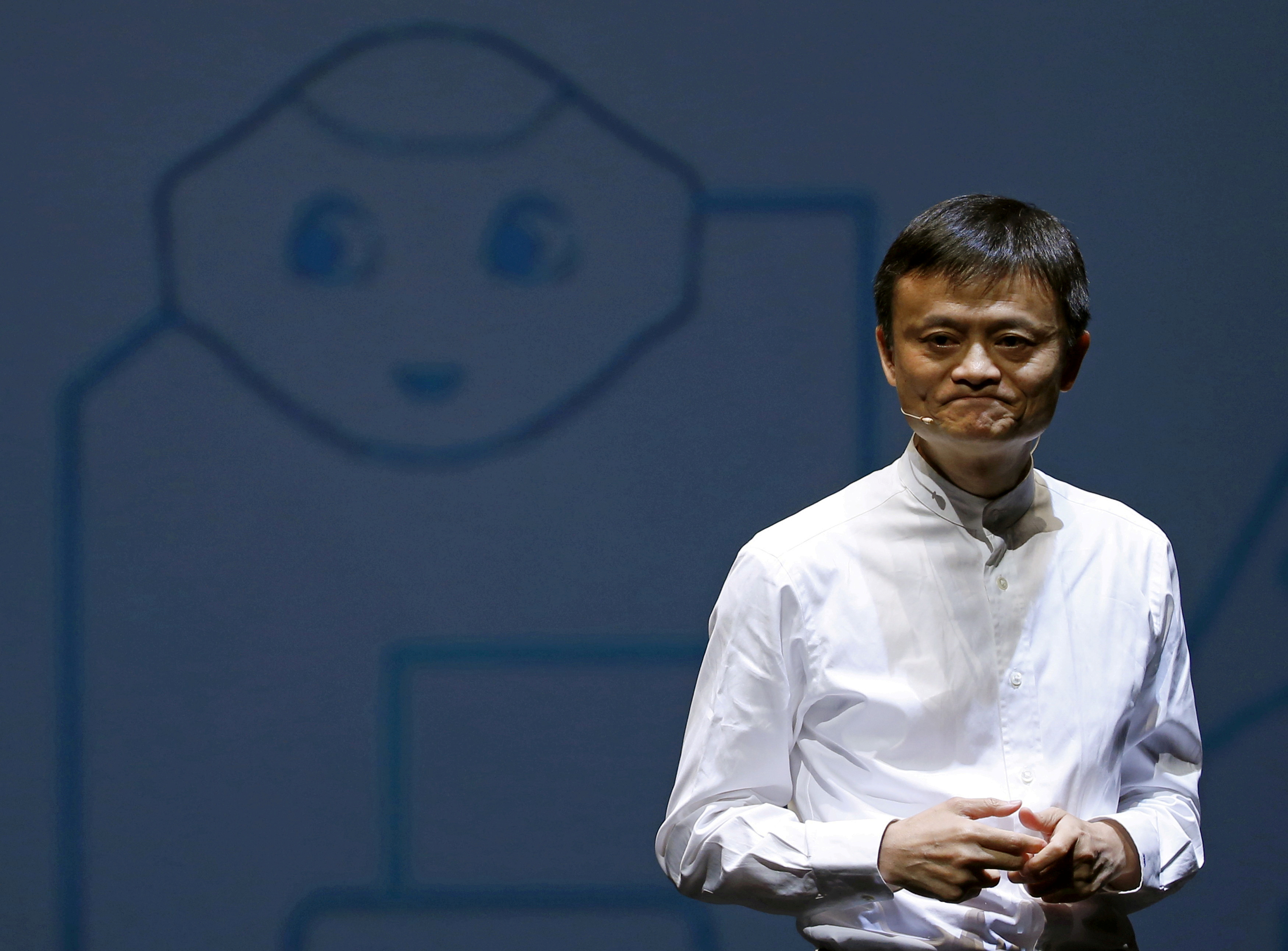 Jack Ma, founder and executive chairman of China's Alibaba Group, speaks in front of a picture of SoftBank's human-like robot named 'pepper' during a news conference in Chiba, Japan, June 18, 2015. REUTERS/Yuya Shino