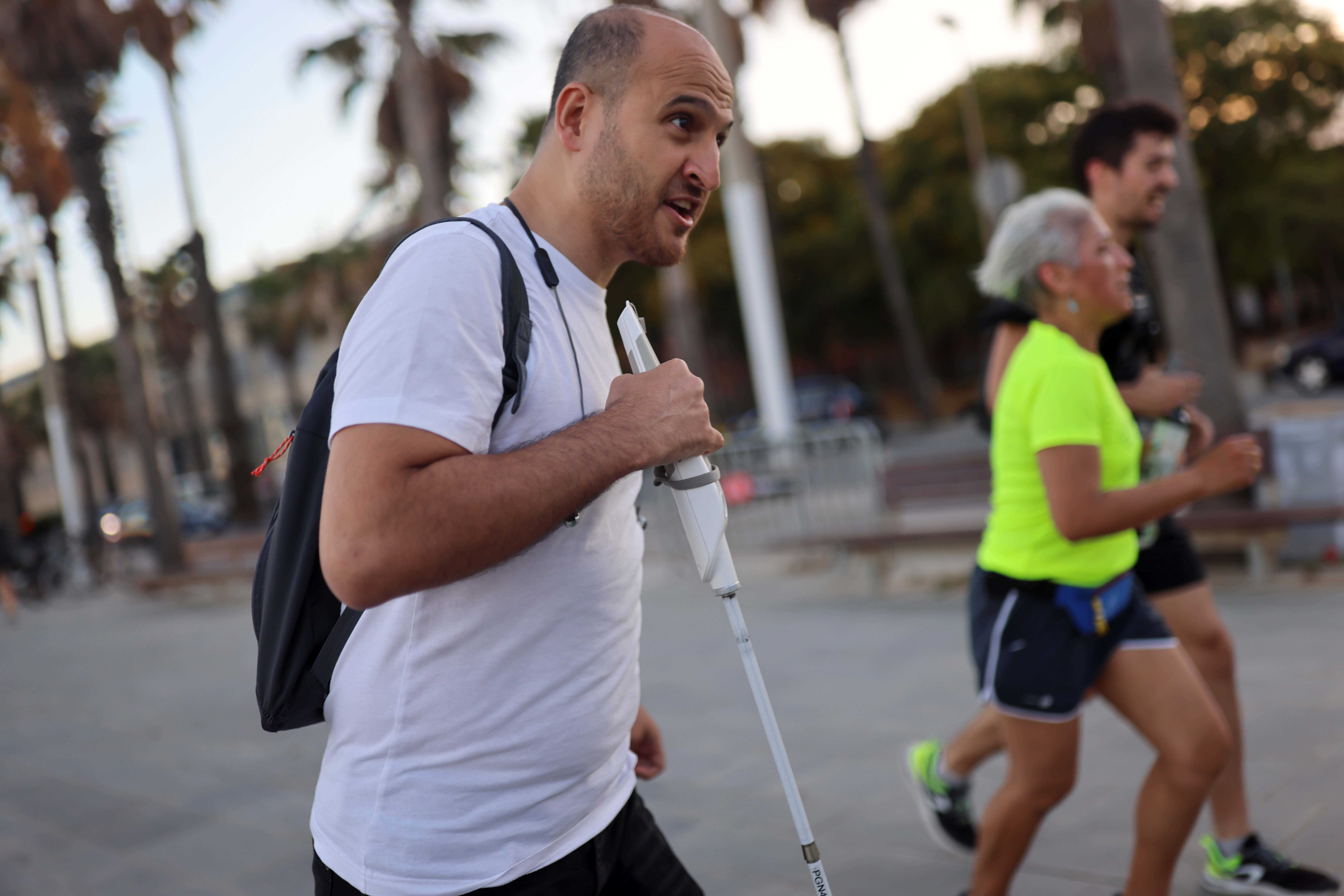 Blind Ceylan, inventor of the WeWalk smart cane, finds his way through a street using  his creation in Barcelona