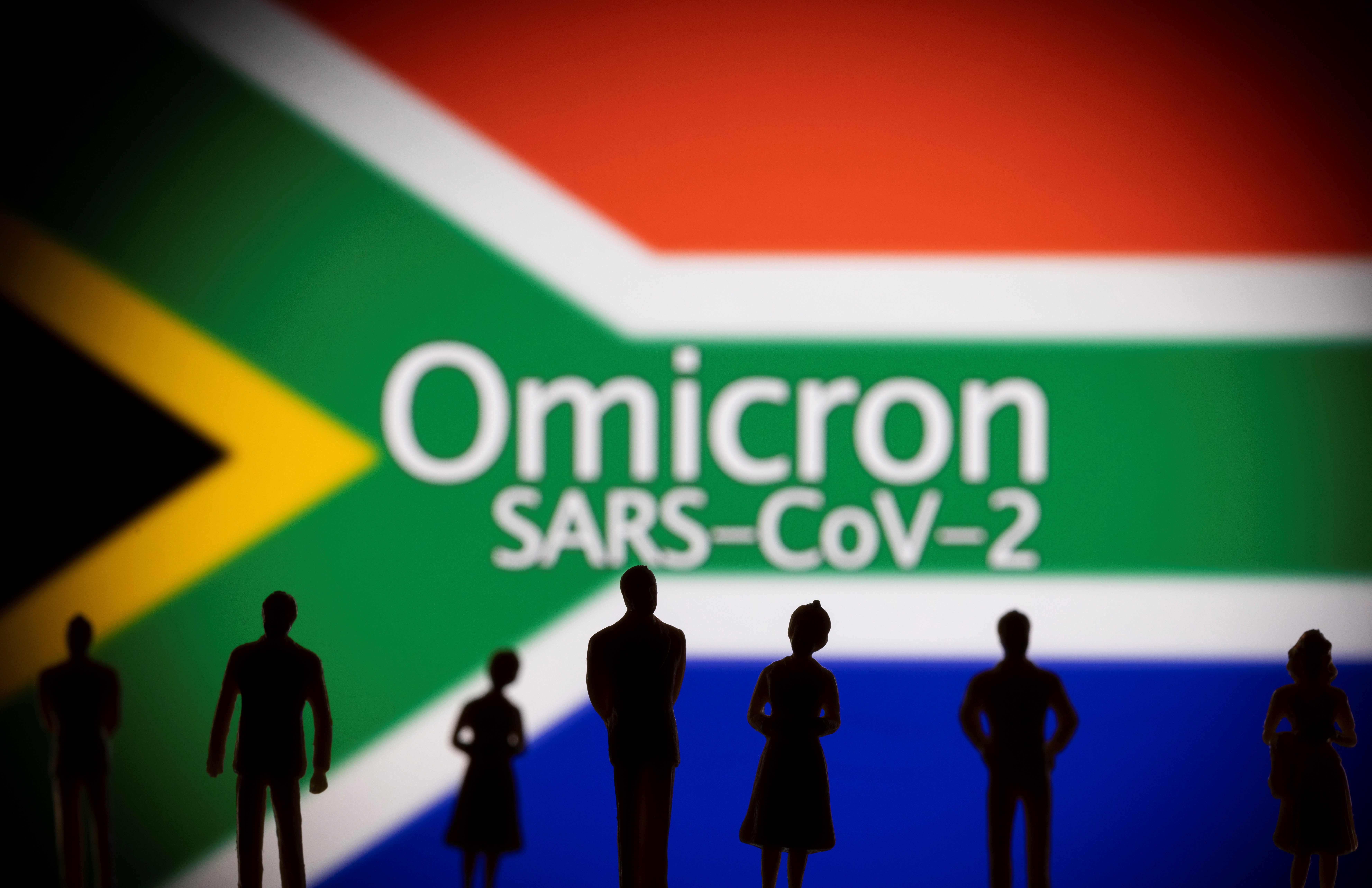 Small toy figures are seen in front of a displayed South Africa flag and words 