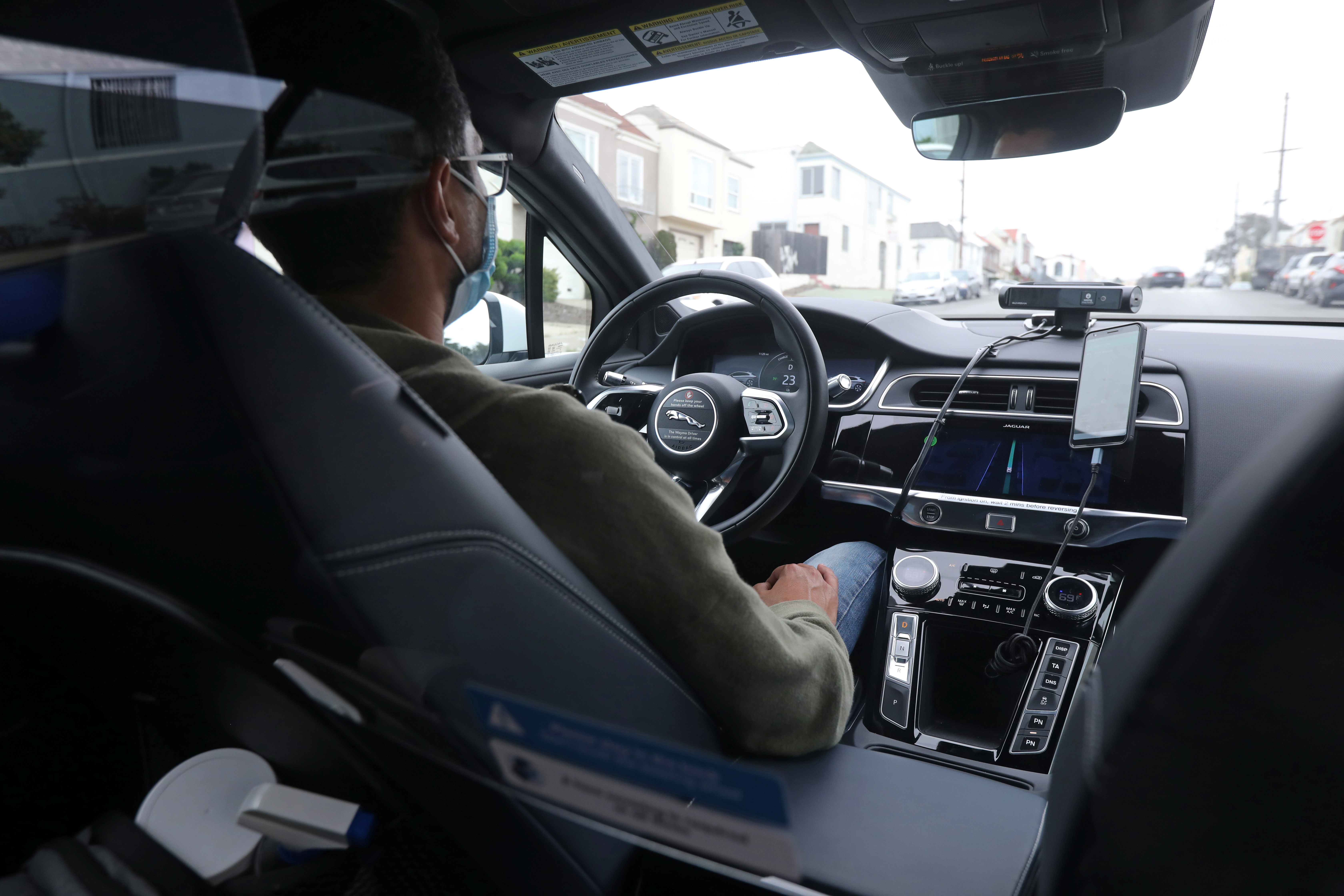 A safety operator is seen in the front seat of a self-driving Waymo vehicle in San Francisco, California, U.S. August 20, 2021. Picture taken August 20, 2021. REUTERS/Nathan Frandino