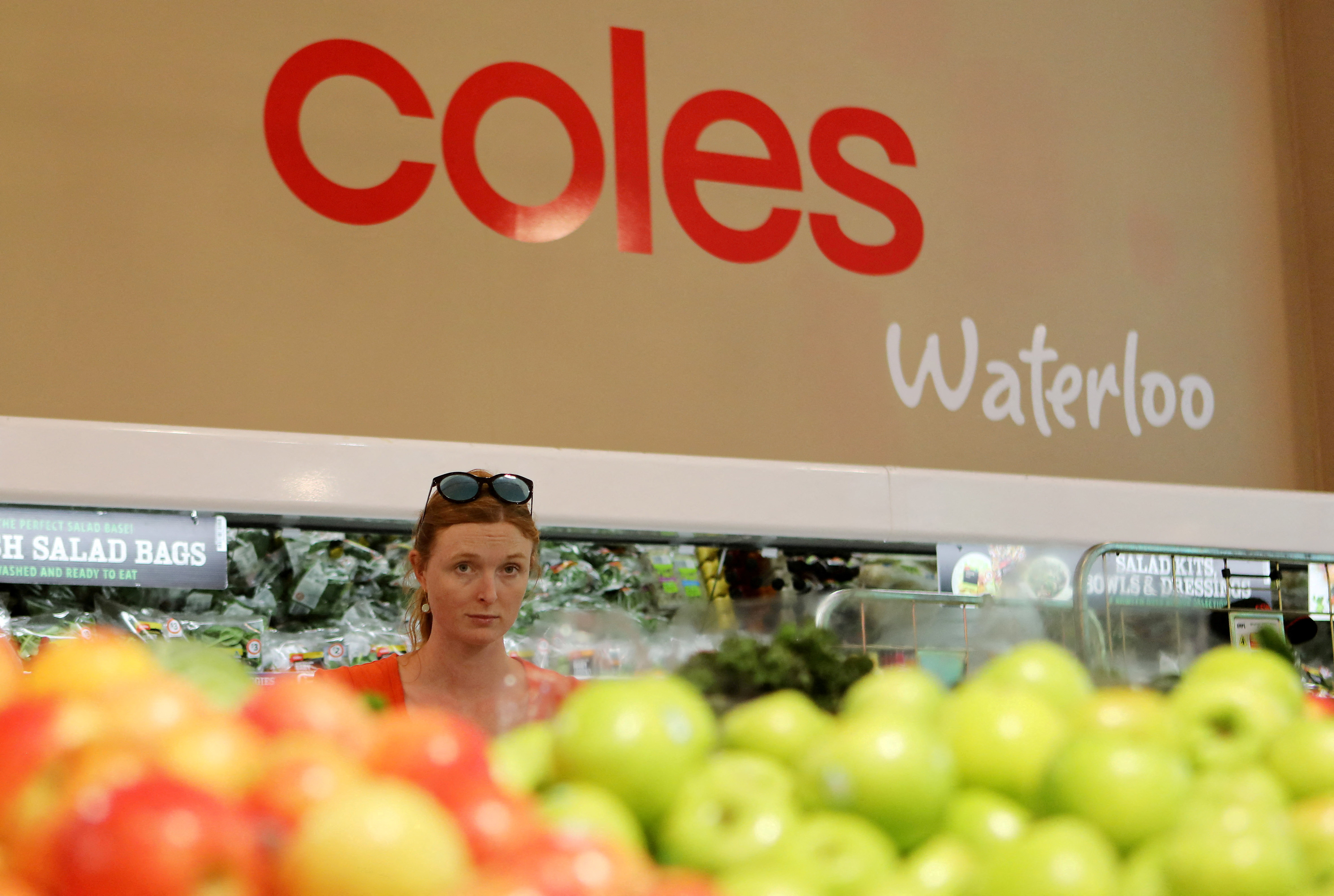 A woman walks in the fruit and vegetables section at a Coles supermarket (main Wesfarmers brand) in Sydney
