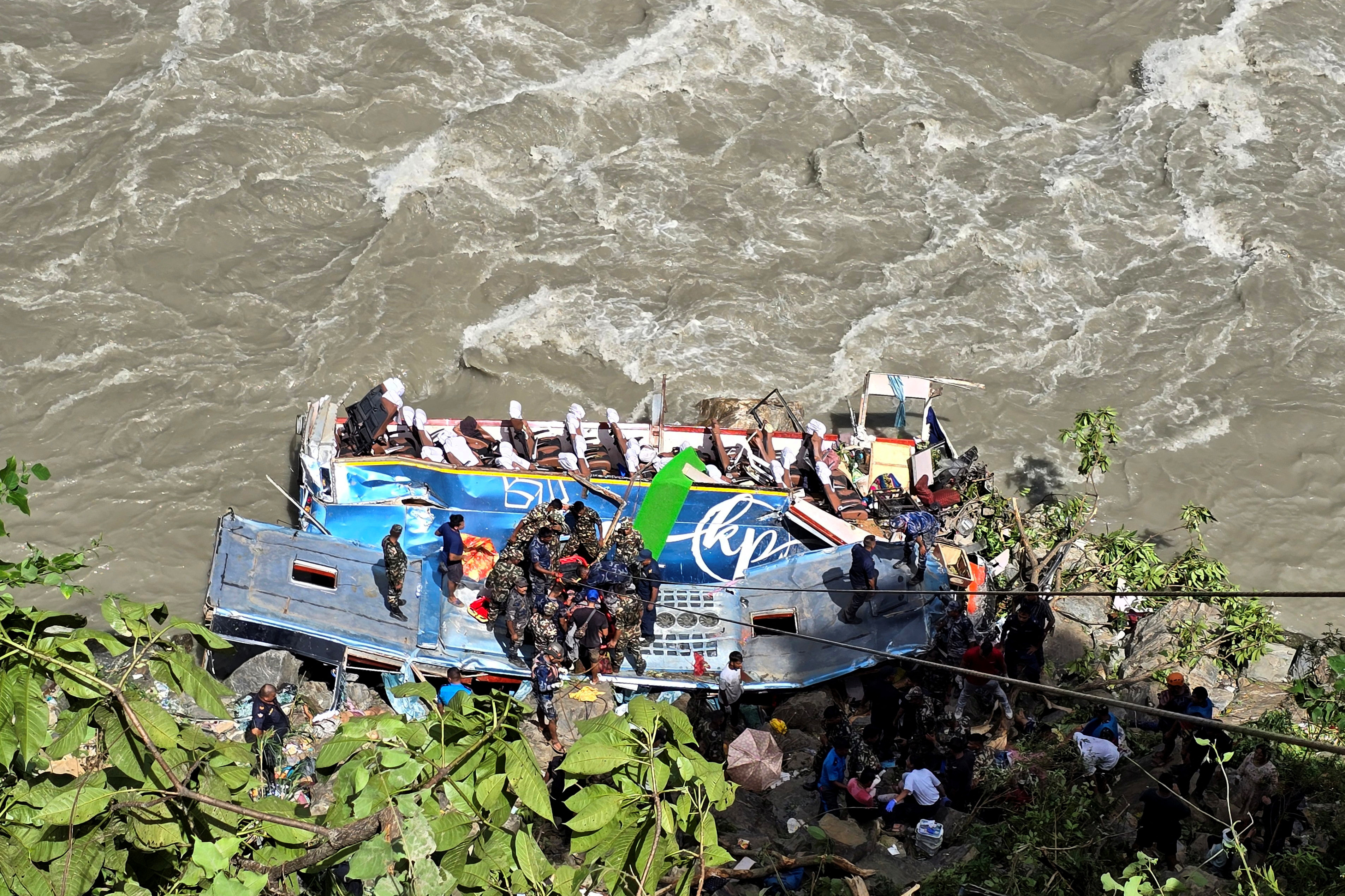 Security force personnel work to rescue injured passengers after a bus carrying Indian passengers traveling to Kathmandu from Pokhara plunged into a river in Tanahun District