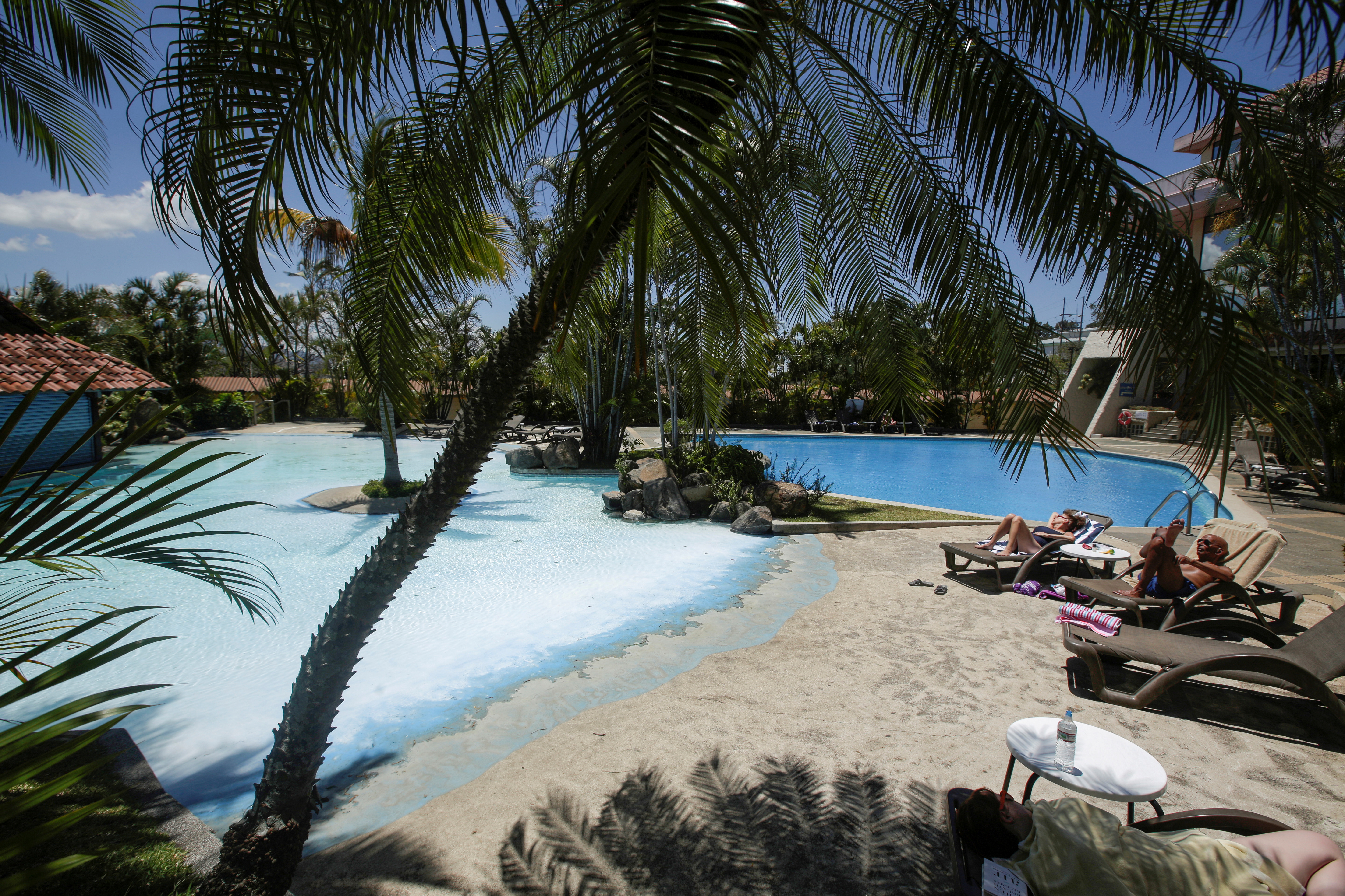 Tourists sunbathe near a pool in a hotel, as Costa Rica tourism industry braces for coronavirus disease (COVID-19) outbreak, in Heredia