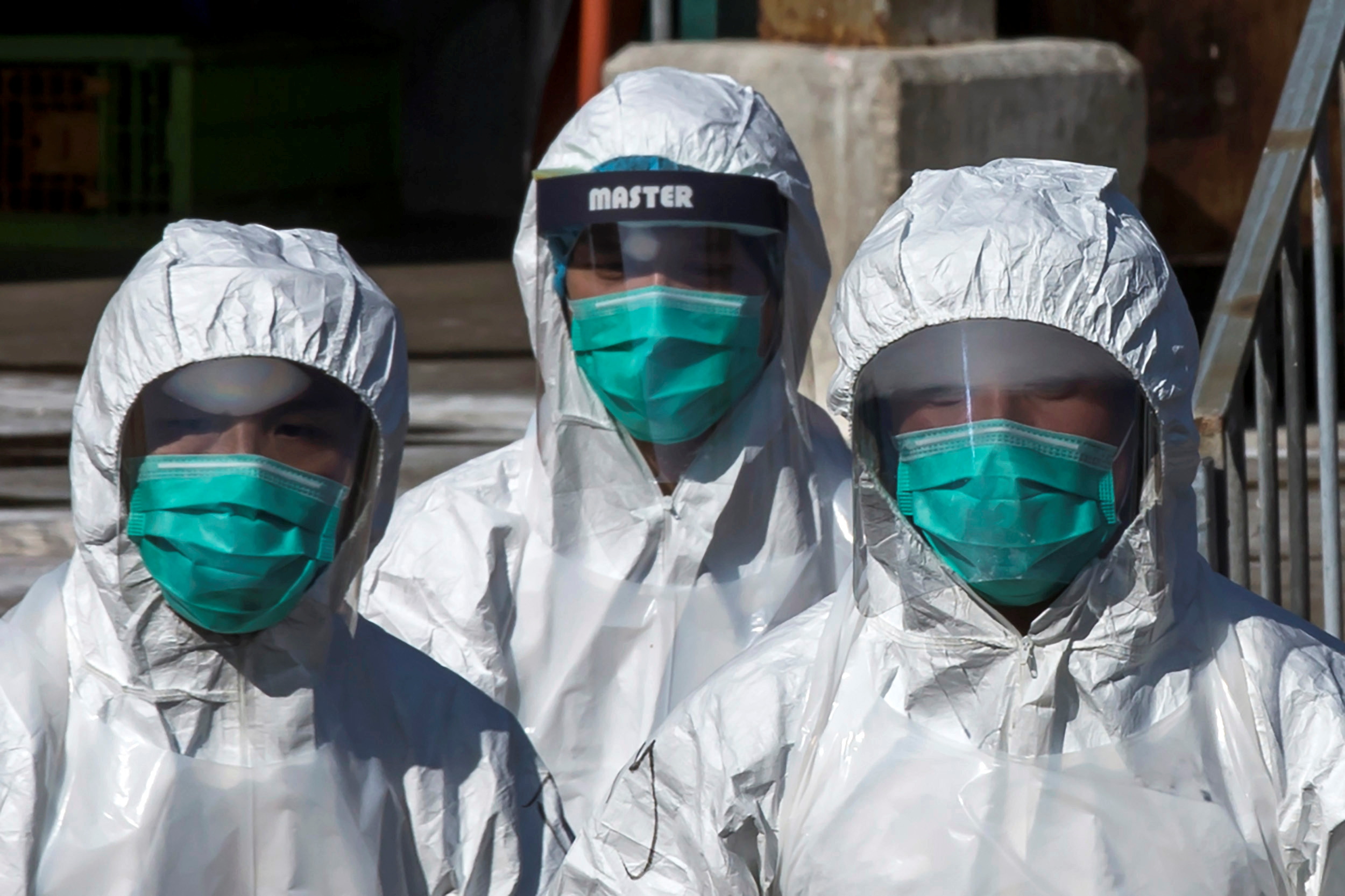 Health officers in full protective gear walk to a wholesale poultry market in Hong Kong December 31, 2014.  REUTERS/Tyrone Siu/File Photo