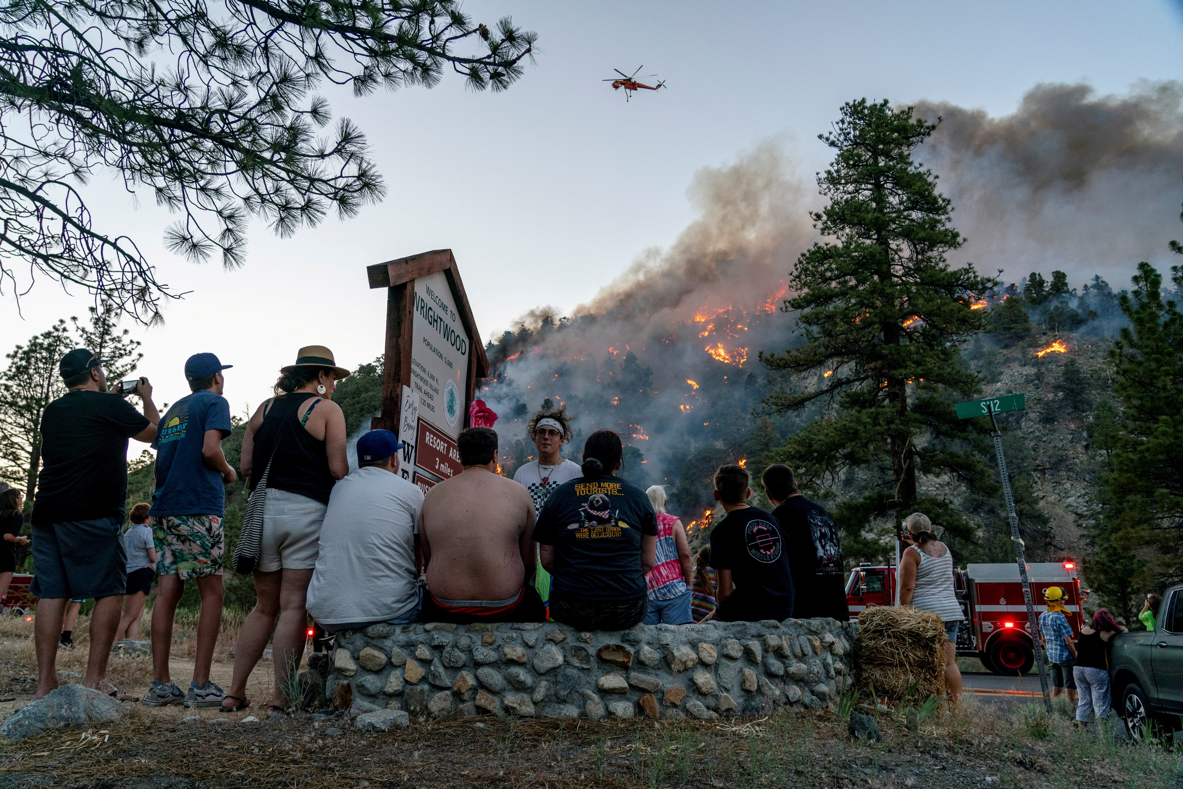 Residents watch part of the Sheep Fire wildfire burn through a hillside in Wrightwood