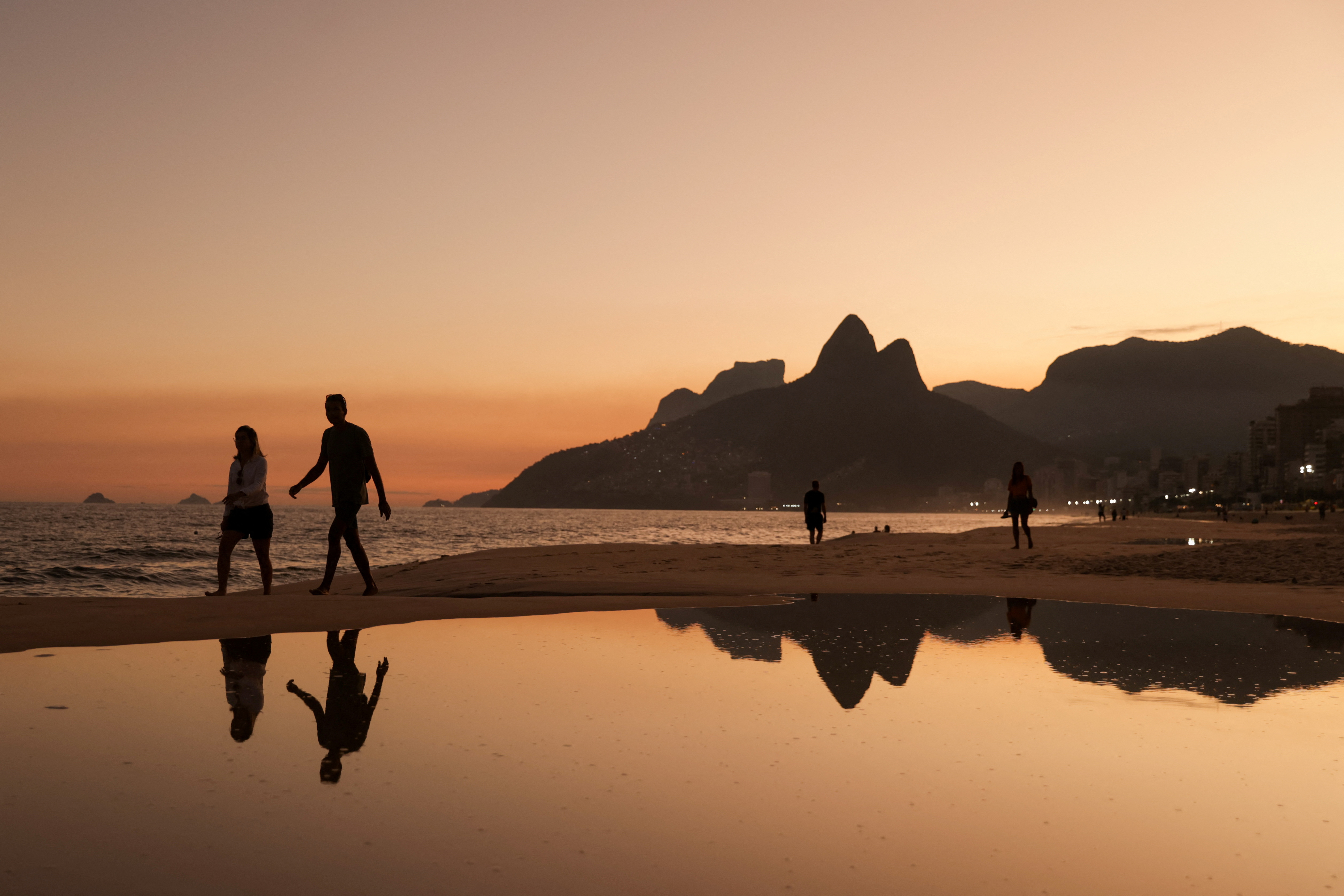 People walk along the Ipanema beach, in Rio de Janeiro