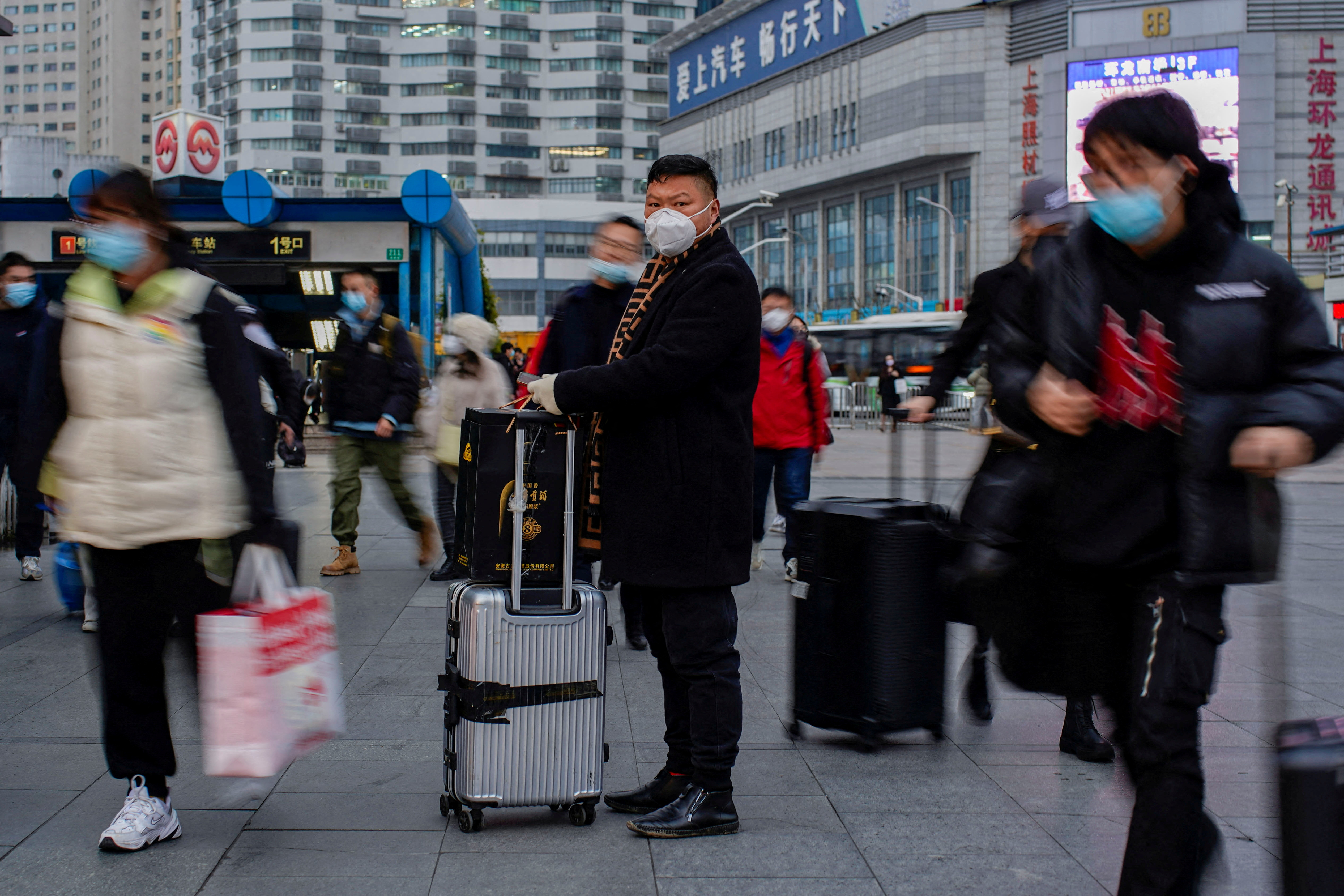 People wearing protective masks walk at the Shanghai Railway Station