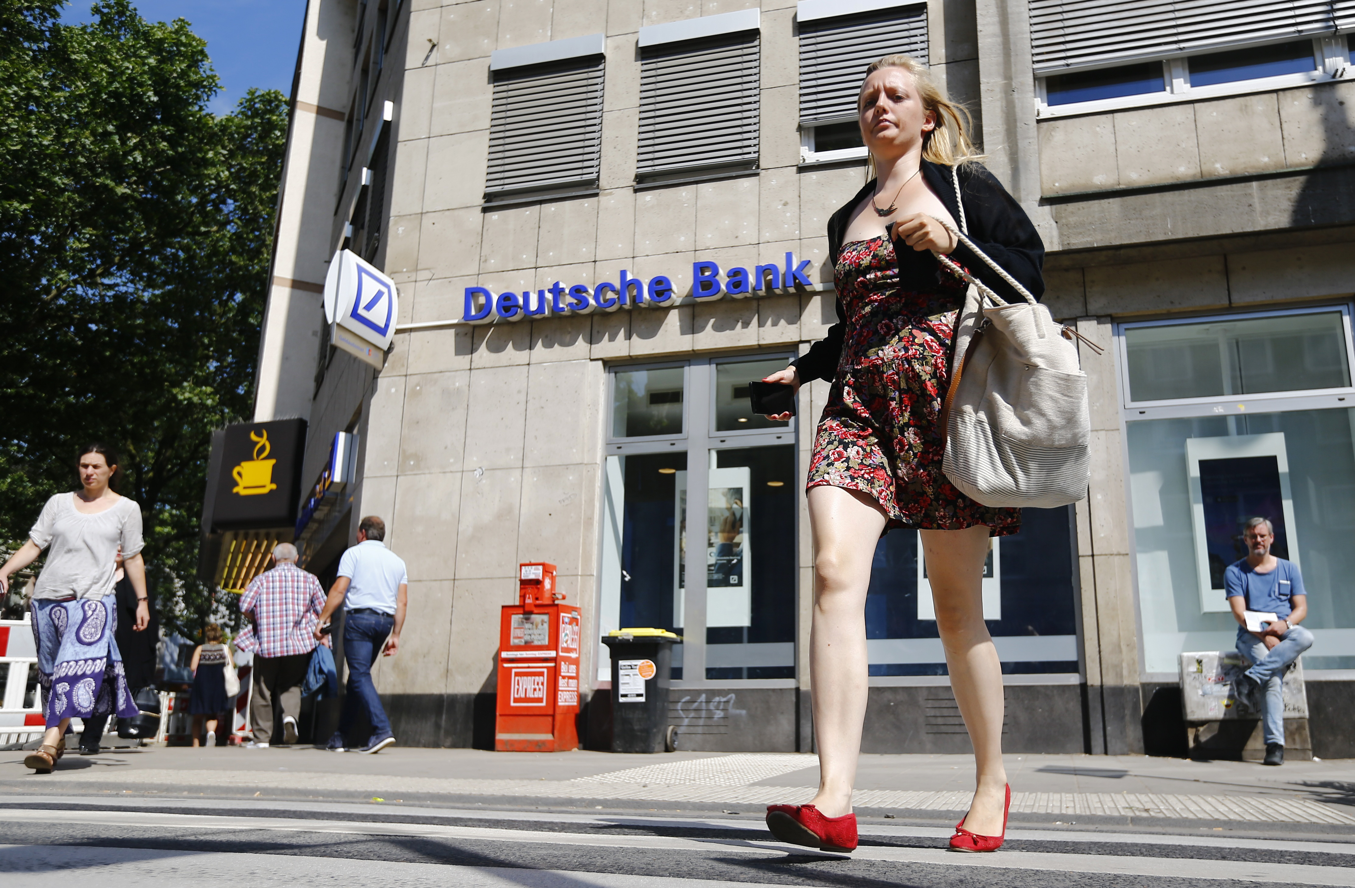 A woman walks in front of a branch of Germany's Deutsche Bank in Cologne