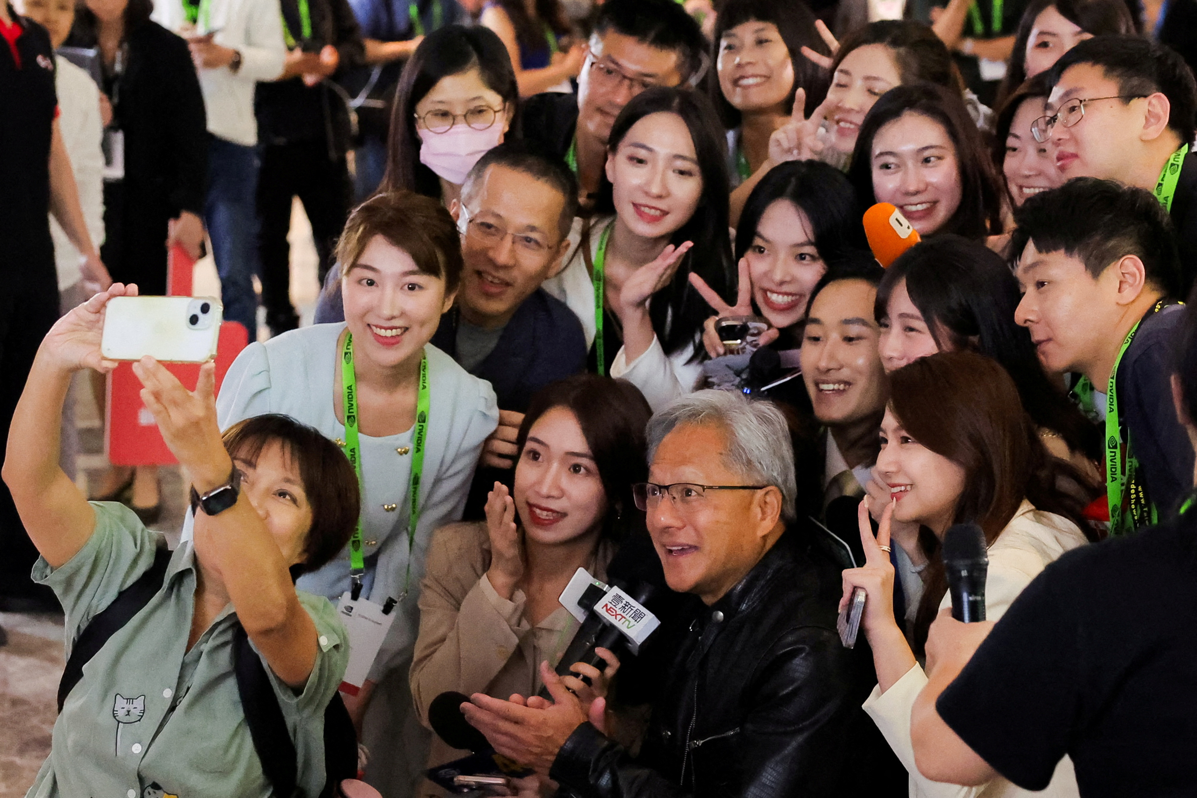 Nvidia CEO Jensen Huang poses for selfie with members of the media at COMPUTEX forum in Taipei
