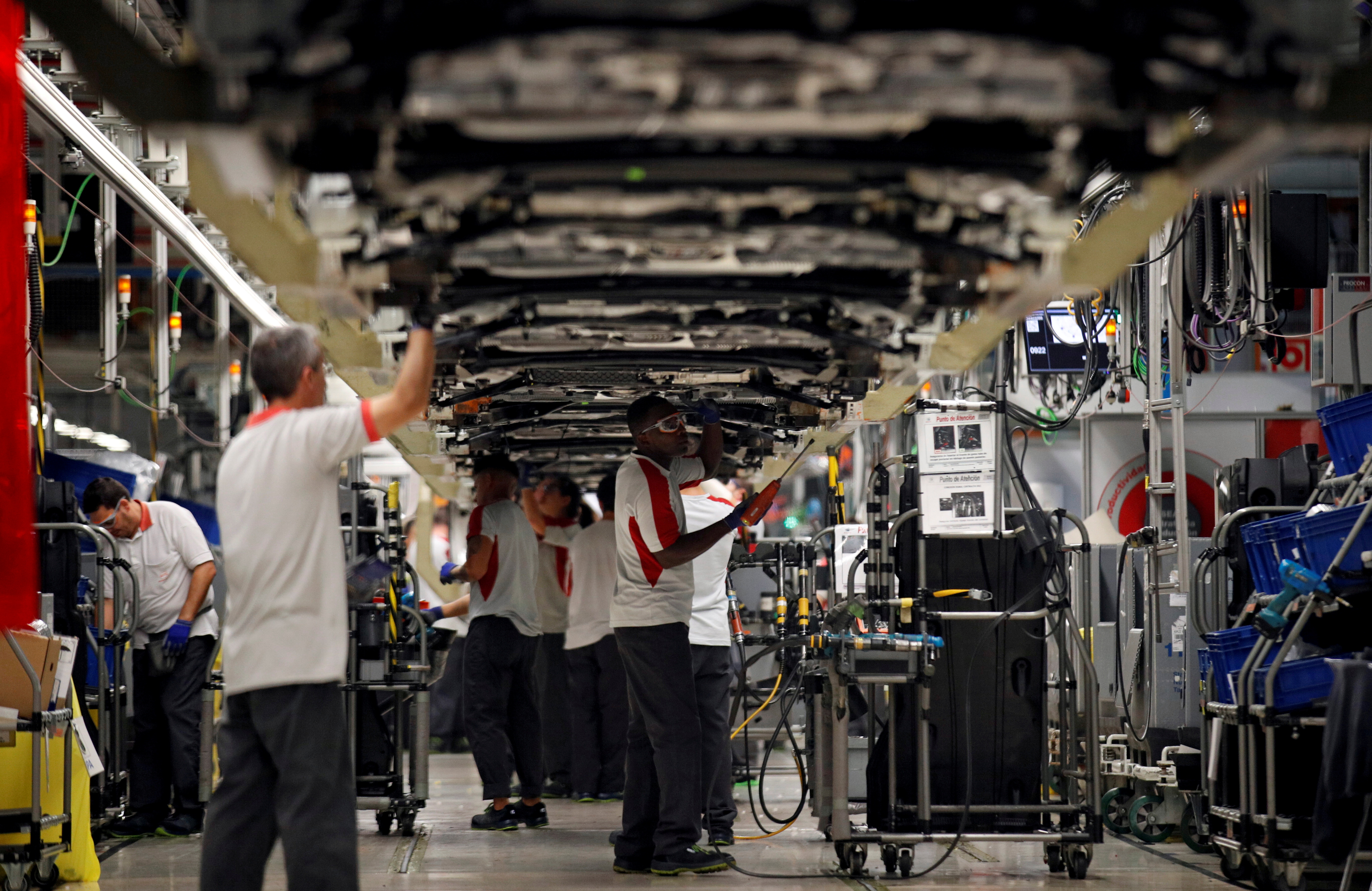 Workers assemble vehicles on the assembly line of the SEAT car factory in Martorell