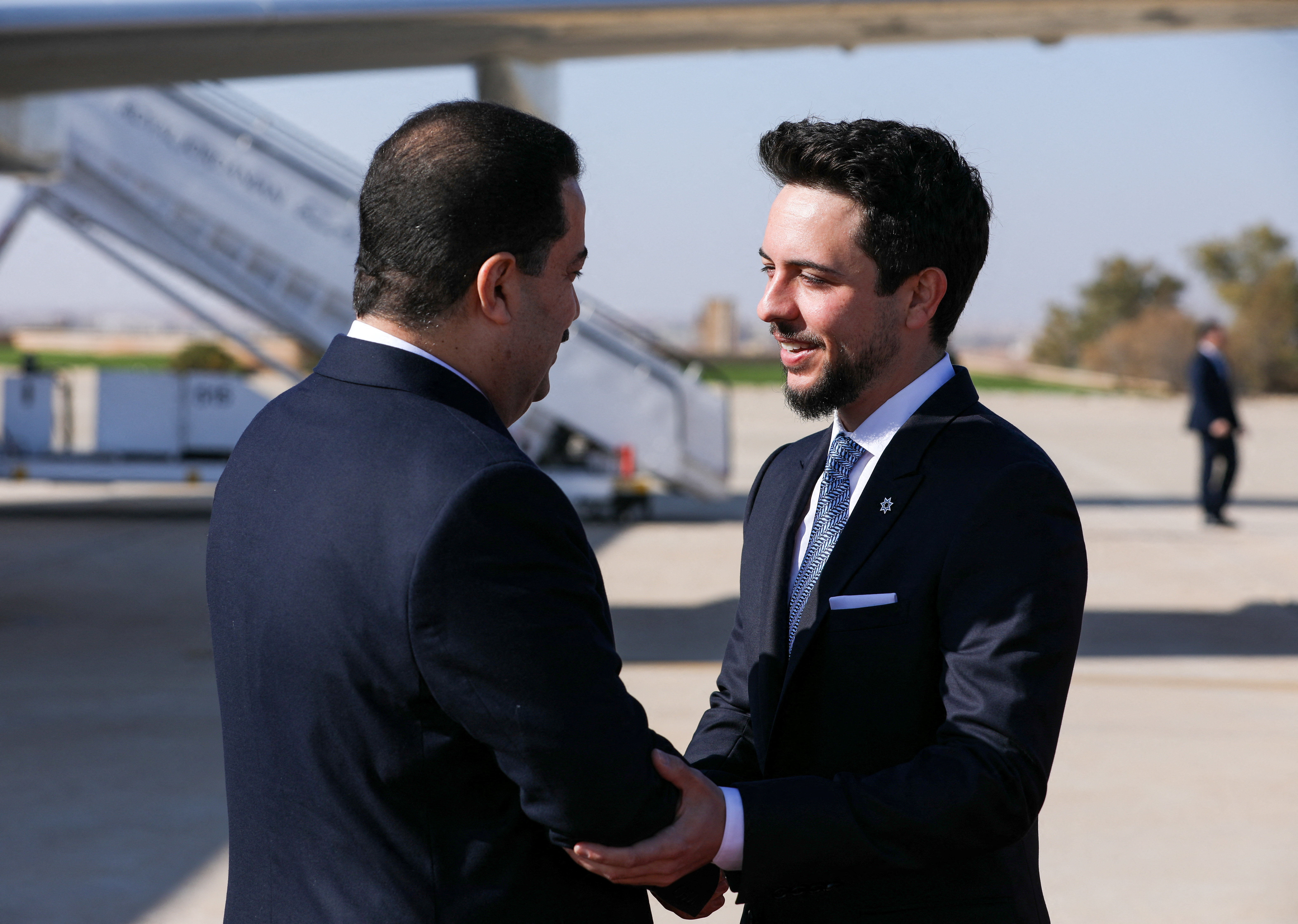 Jordan's Crown Prince Hussein welcomes Iraqi Prime Minister Mohammed Shia al-Sudani upon his arrival at Queen Alia International Airport in Amman
