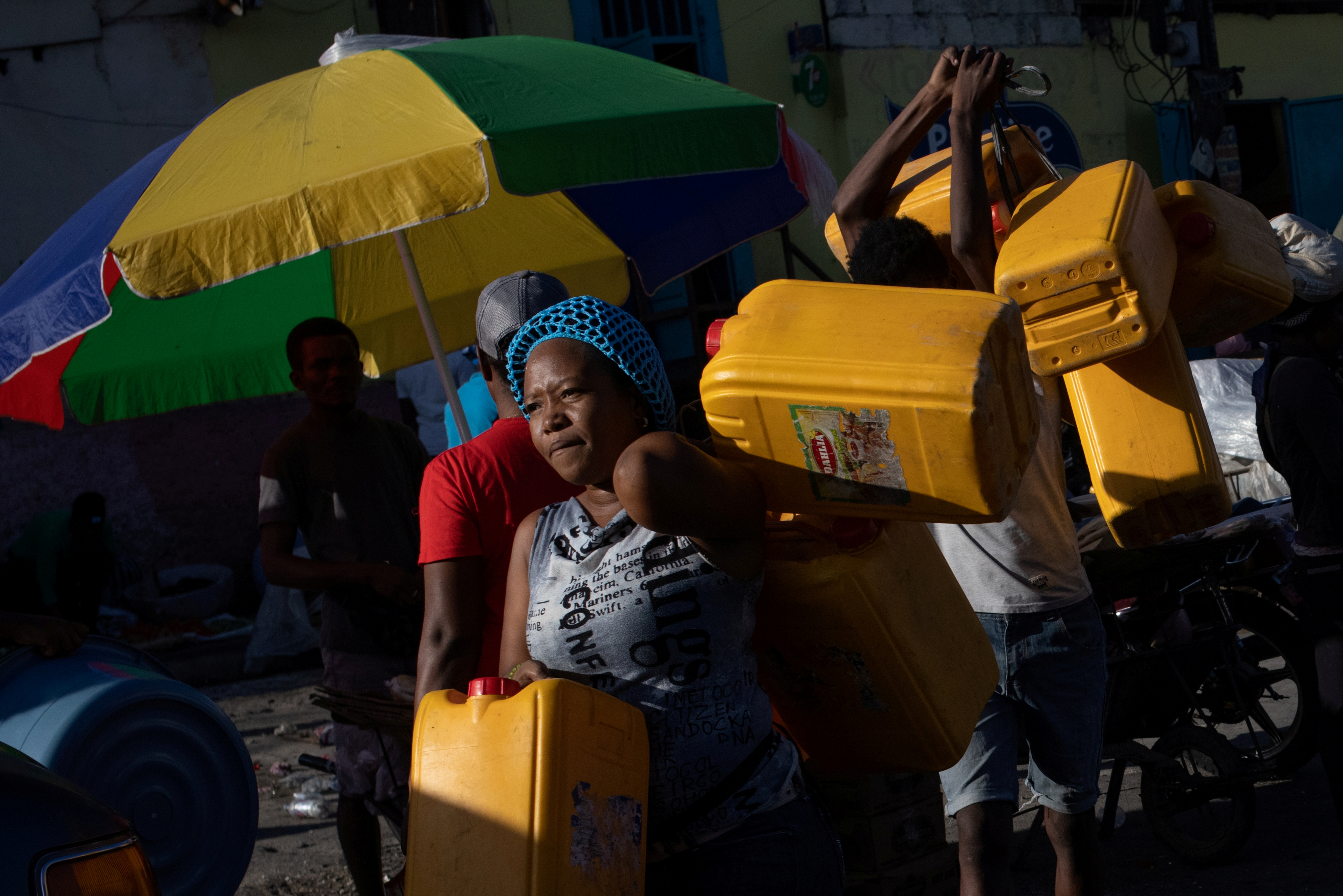 Locals carry containers, used for oil and gasoline, during fuel shortages in Port-au-Prince, Haiti October 24, 2021.  REUTERS/Adrees Latif