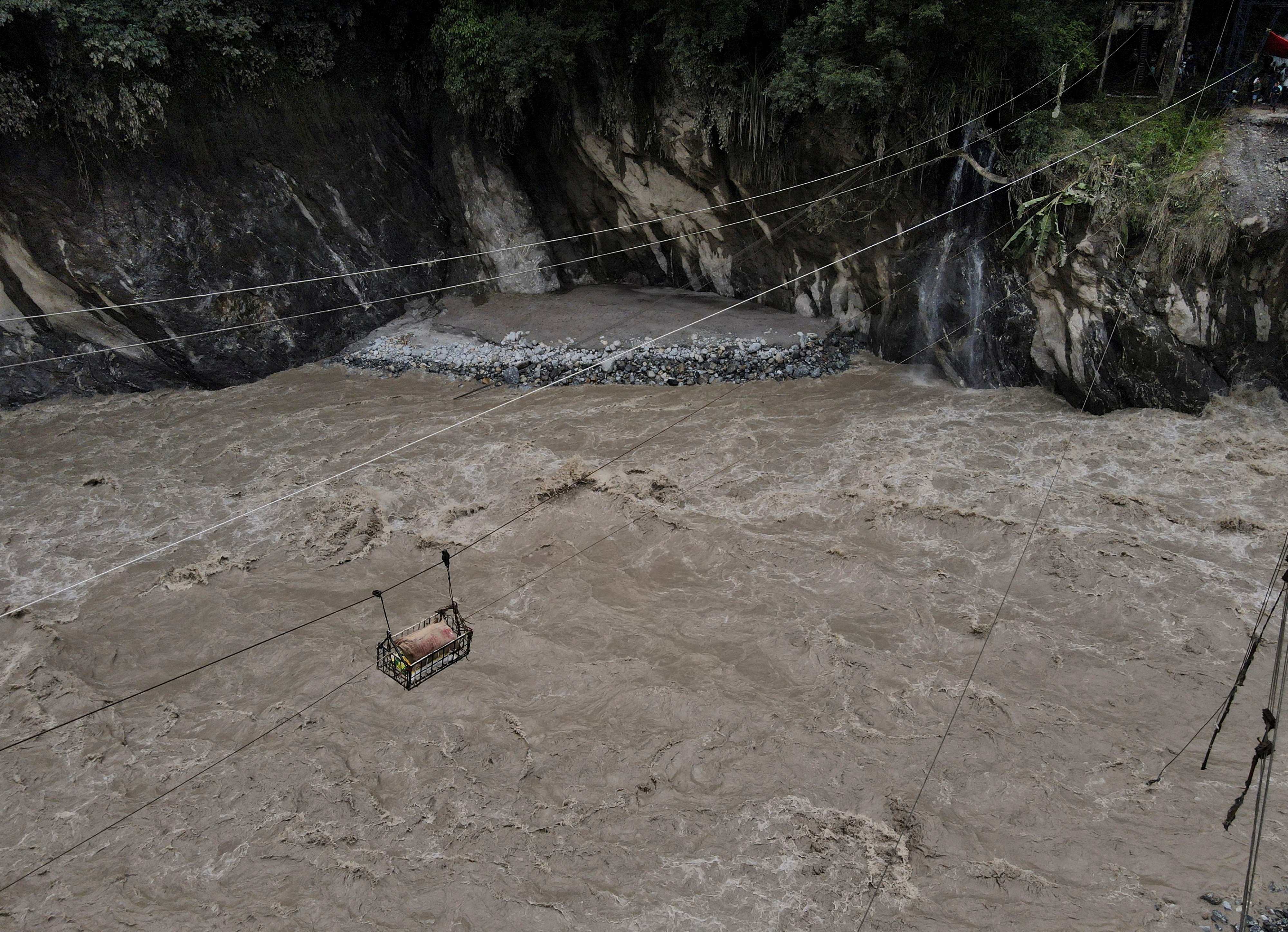 A drone view of a basket carrying relief supplies is sent on a makeshift zip line across the Teesta river to Dzongu village that became inaccessible after flash floods, washed away a bridge at Sangkalang, Sikkim