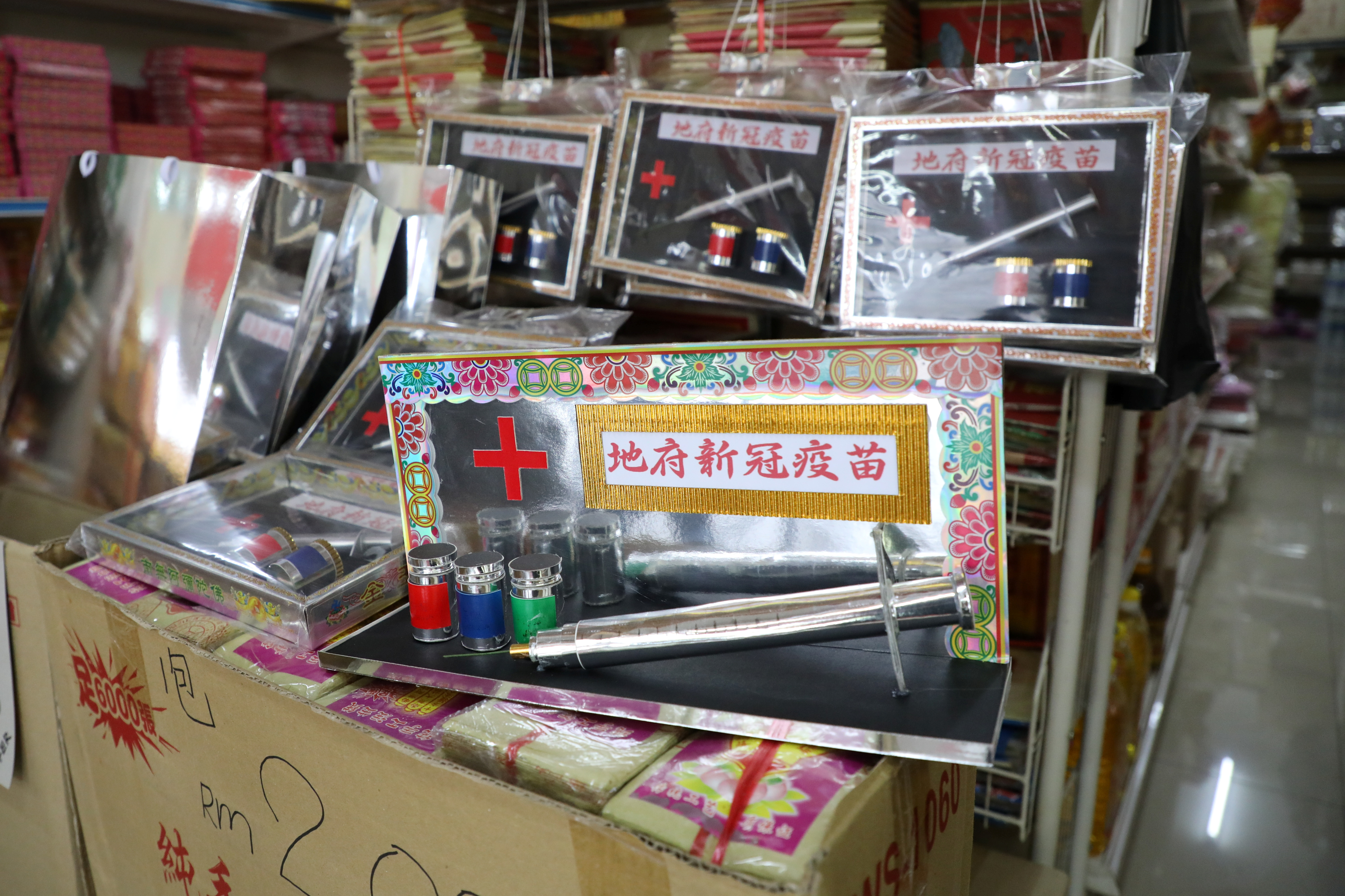 Handmade paper vaccines are displayed for sale at a prayer paraphernalia shop in Johor Bahru