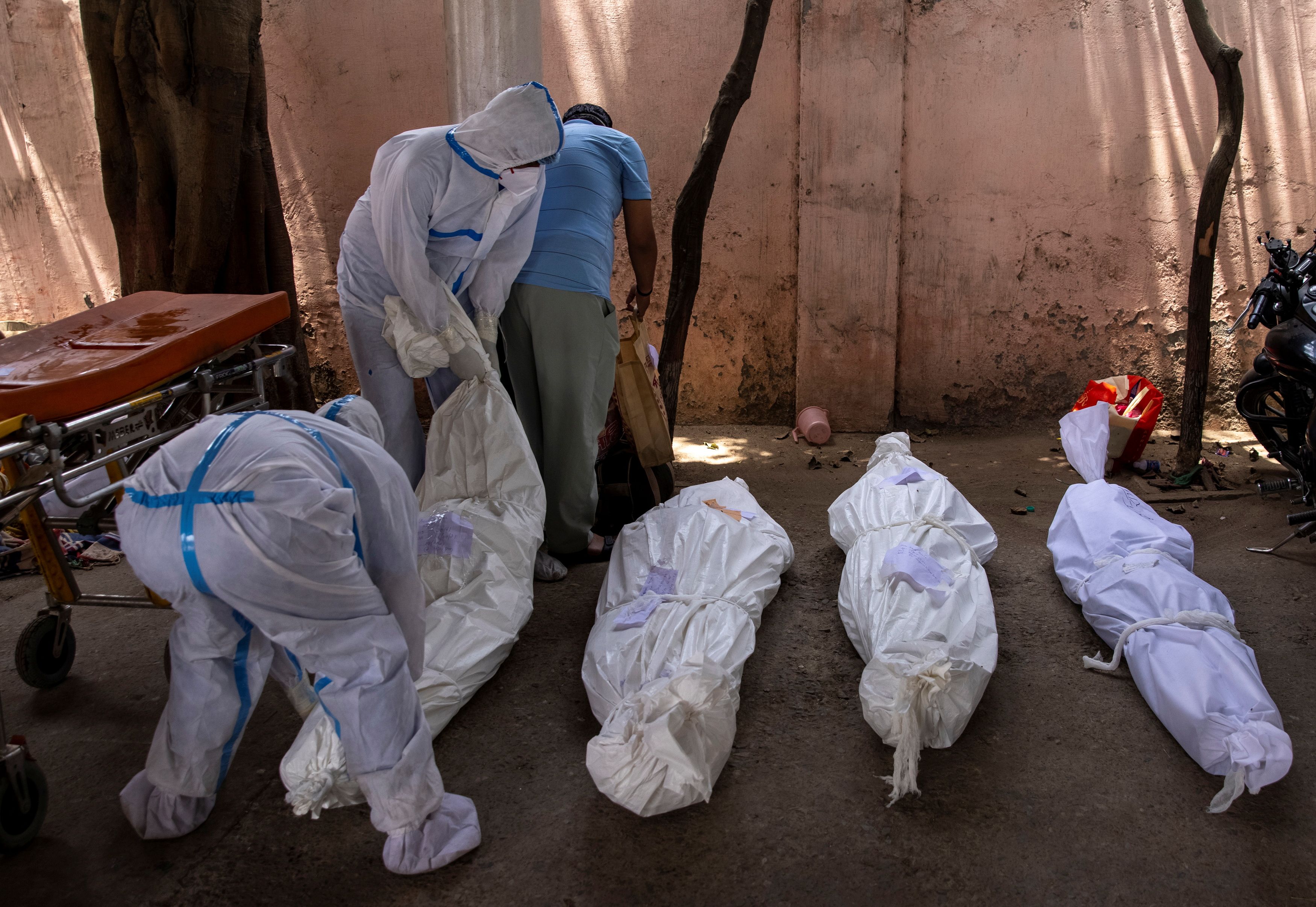 India Covid cases cross 18 million, gravediggers work round the clock 7 Healthcare workers place the body of a person, who died due to the coronavirus disease (COVID-19), on the ground for cremation at a crematorium ground in New Delhi, India, April 28, 2021. REUTERS/Danish Siddiqui