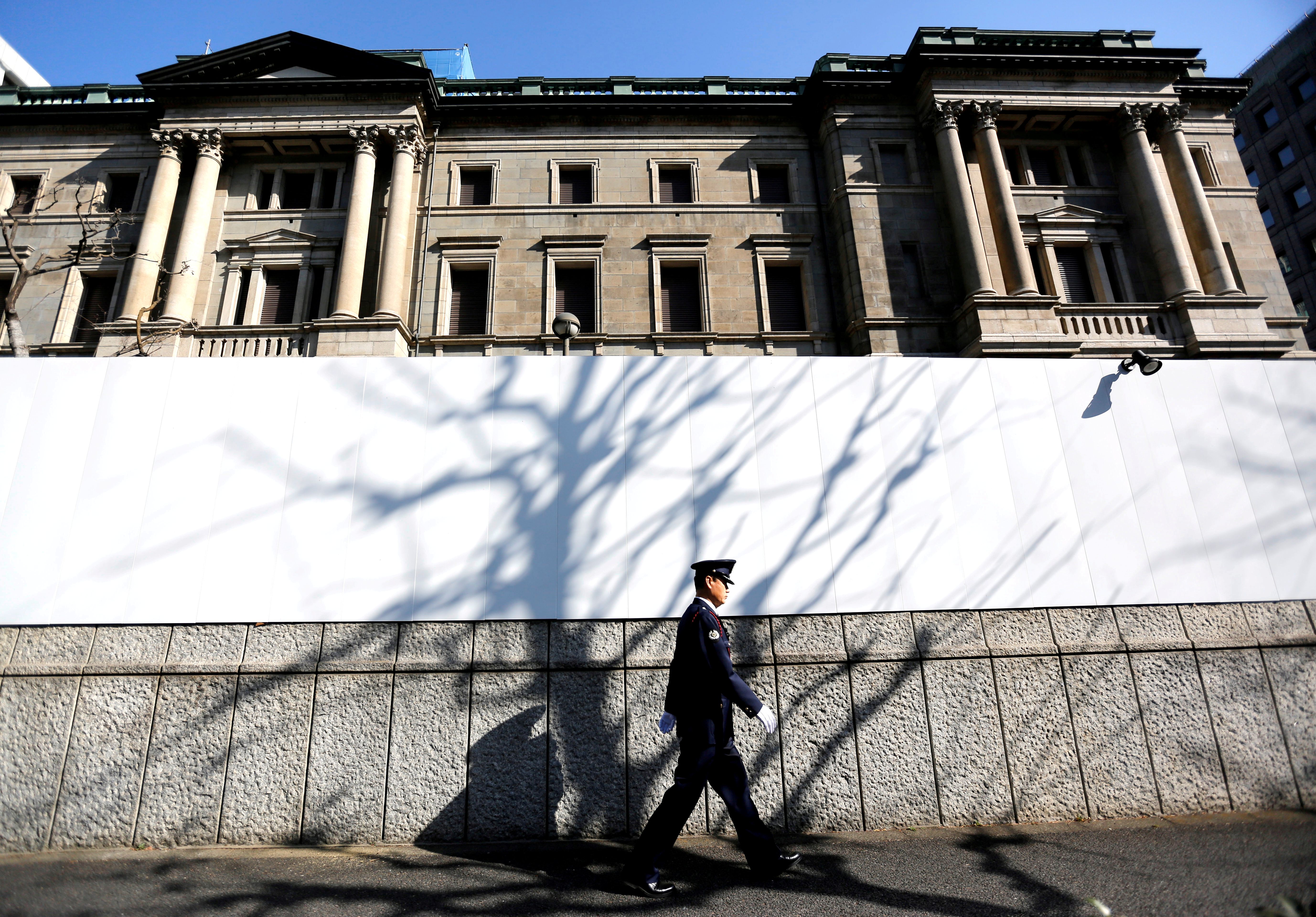 A security guard walks past in front of the Bank of Japan headquarters in Tokyo