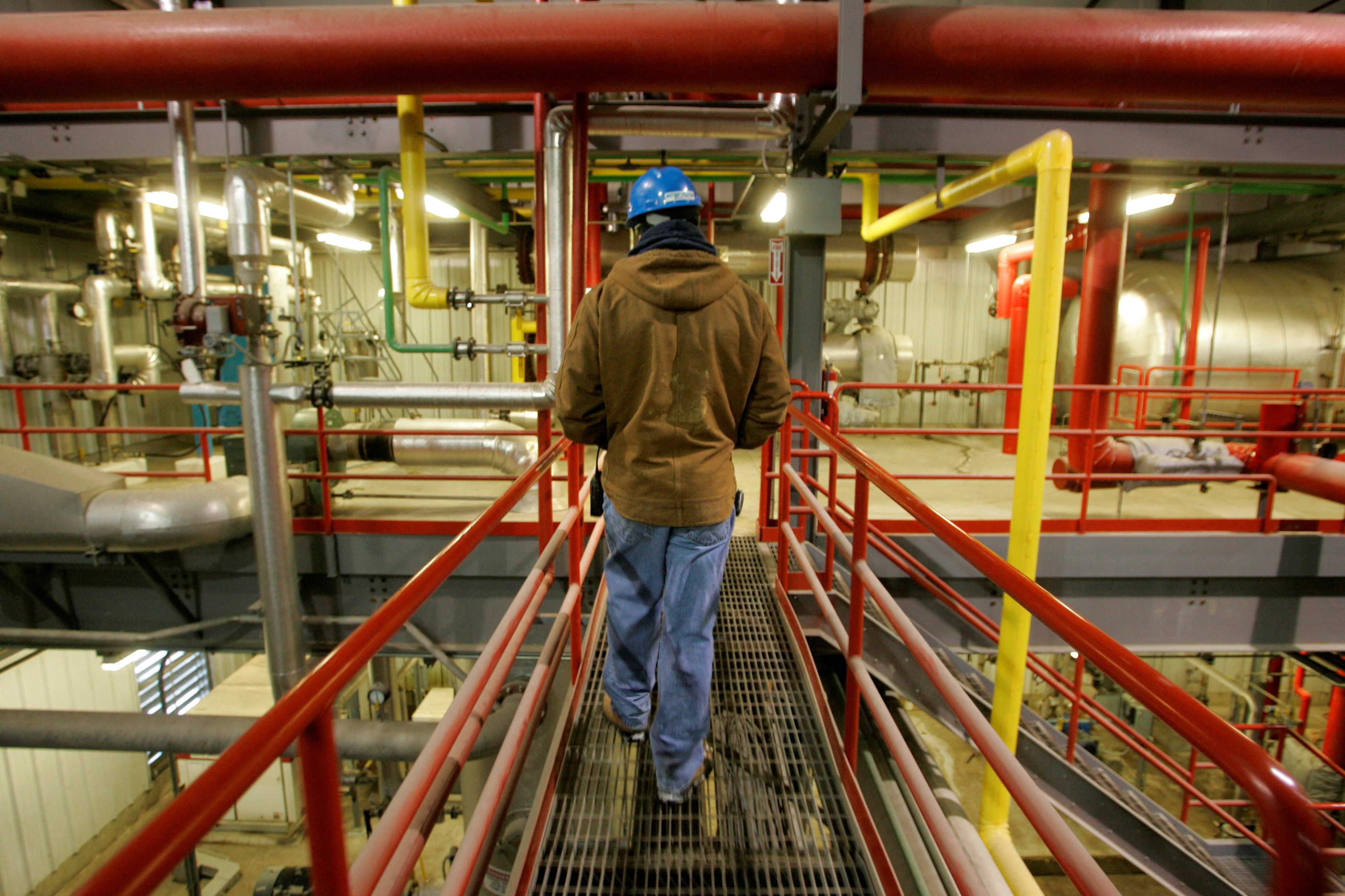 Travis Harrison walks among the pipes that process corn into ethanol at the Lincolnway Energy plant in Nevada, Iowa